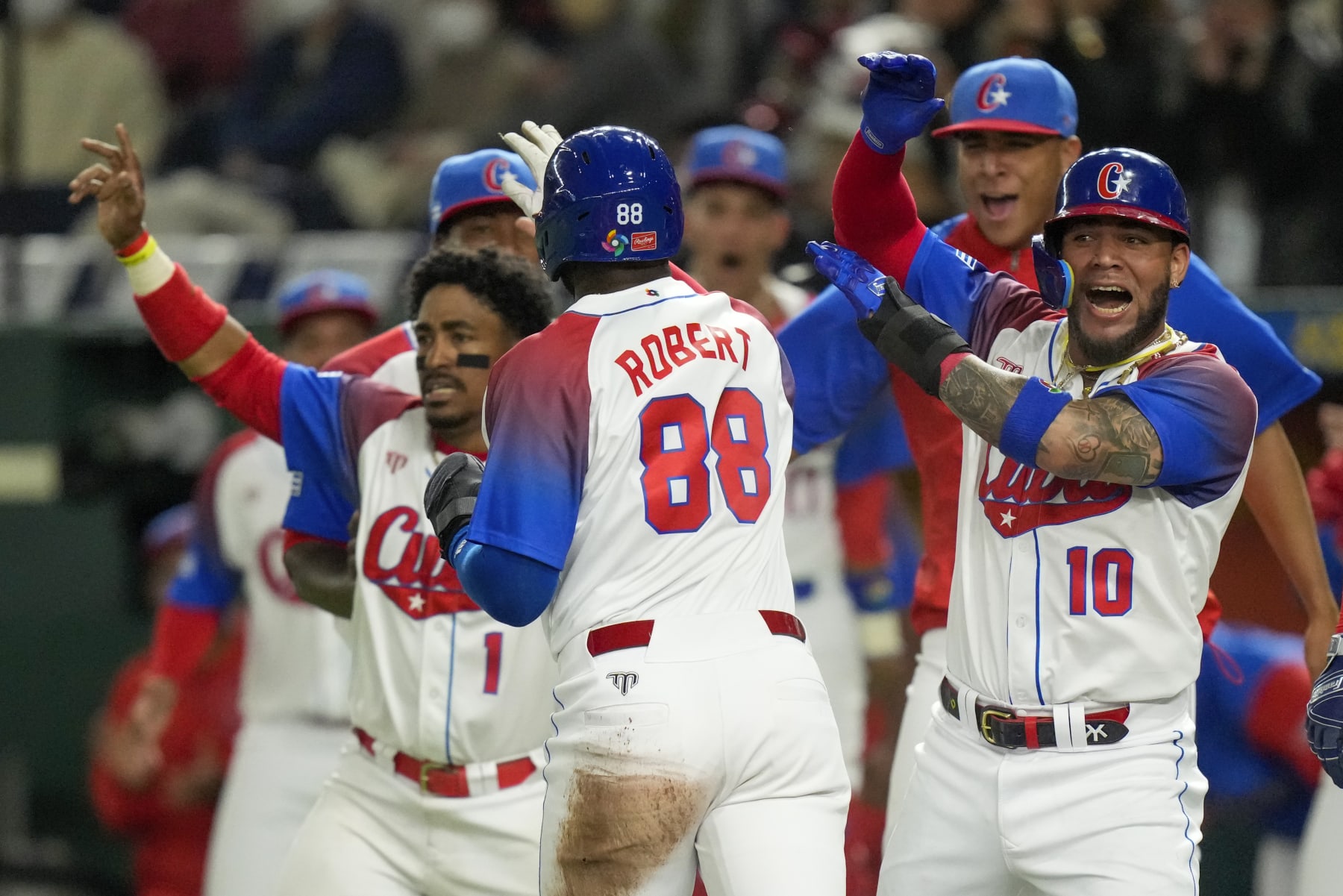 Yoan Moncada, right, of Cuba congratulates teammate Luis Robert Jr. as he runs home during the World Baseball Classic quarterfinal game between Cuba and Australia at the Tokyo Dome Tokyo, Wednesday, March 15, 2023. (AP Photo/Eugene Hoshiko)