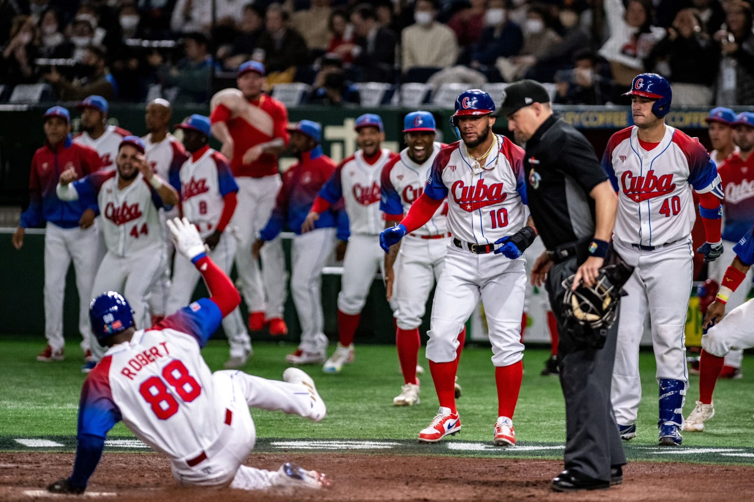 Members of Team Cuba reacts as Cuba's Luis Robert Jr. sliding to home plate during the World Baseball Classic (WBC) quarter-final game between Cuba and Australia at the Tokyo Dome in Tokyo on March 15, 2023. (Photo by Philip FONG / AFP) (Photo by PHILIP FONG/AFP via Getty Images) Members of Team Cuba reacts as Cuba's Luis Robert Jr. sliding to home plate during the World Baseball Classic (WBC) quarter-final game between Cuba and Australia at the Tokyo Dome in Tokyo on March 15, 2023. (Photo by Philip FONG / AFP) (Photo by PHILIP FONG/AFP via Getty Images)