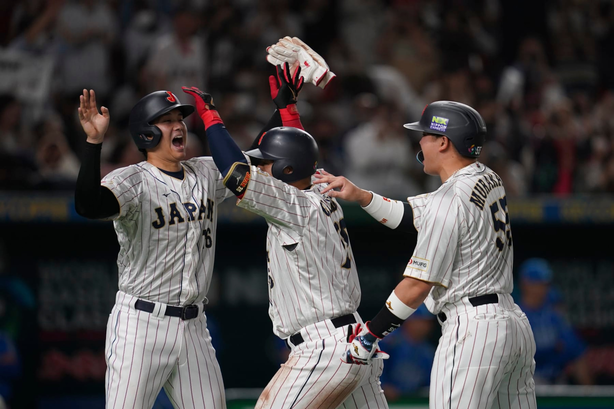 Kazuma Okamoto of Japan, center celebrates with Shohei Ohtani of Japan, left, and Munetaka Murakami of Japan after hitting a three-run home run during the third inning of the quarterfinal game between Italy and Japan at the World Baseball Classic (WBC) at Tokyo Dome in Tokyo, Japan, Thursday, March 16, 2023. (AP Photo/Toru Hanai)