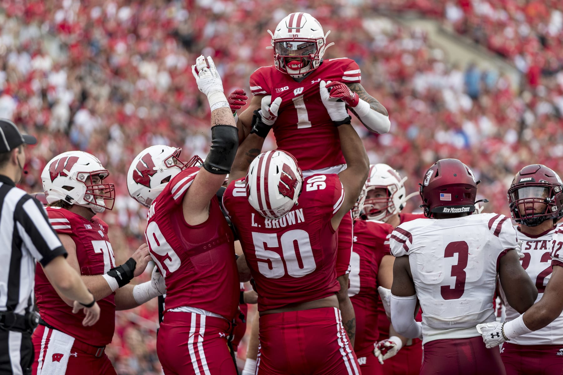 MADISON, WI - SEPTEMBER 17: Wisconsin Badgers offensive lineman Logan Brown (50) lifts up Wisconsin Badgers running back Chez Mellusi (1) in celebration of a touchdown run durning a college football game between the New Mexico State Aggies and the Wisconsin Badgers on September 17th, 2022 at Barry Alvarez field in Camp Randall Stadium in Madison, WI. (Photo by Dan Sanger/Icon Sportswire via Getty Images)