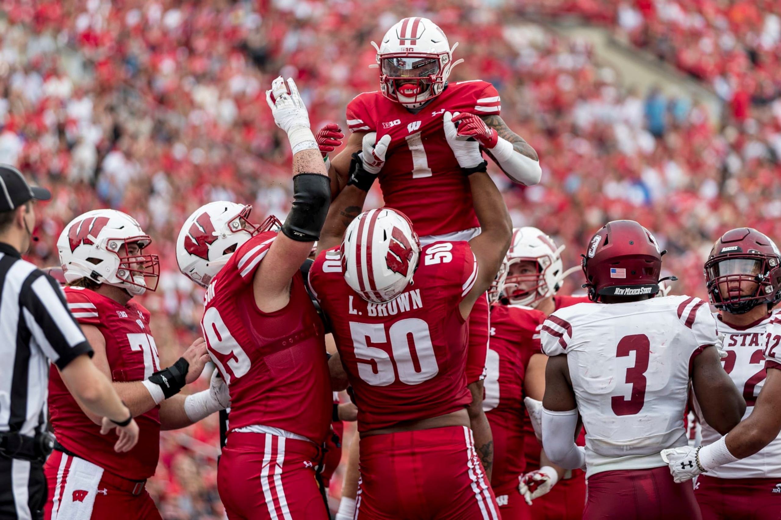 MADISON, WI - SEPTEMBER 17: Wisconsin Badgers offensive lineman Logan Brown (50) lifts up Wisconsin Badgers running back Chez Mellusi (1) in celebration of a touchdown run durning a college football game between the New Mexico State Aggies and the Wisconsin Badgers on September 17th, 2022 at Barry Alvarez field in Camp Randall Stadium in Madison, WI. (Photo by Dan Sanger/Icon Sportswire via Getty Images)