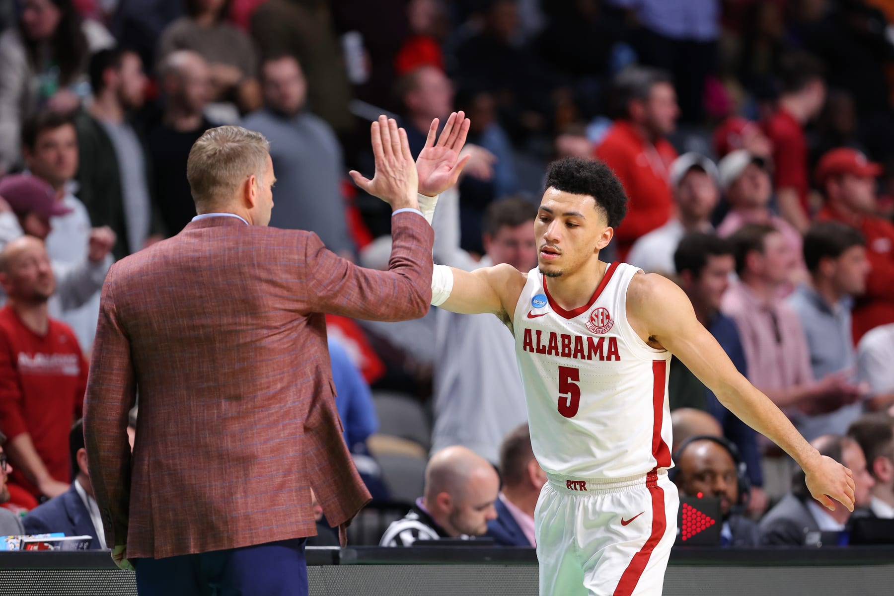 BIRMINGHAM, ALABAMA - MARCH 18: Jahvon Quinerly #5 of the Alabama Crimson Tide gives head coach Nate Oats a high five during the second half against the Maryland Terrapins in the second round of the NCAA Men's Basketball Tournament at Legacy Arena at the BJCC on March 18, 2023 in Birmingham, Alabama. (Photo by Kevin C. Cox/Getty Images)
