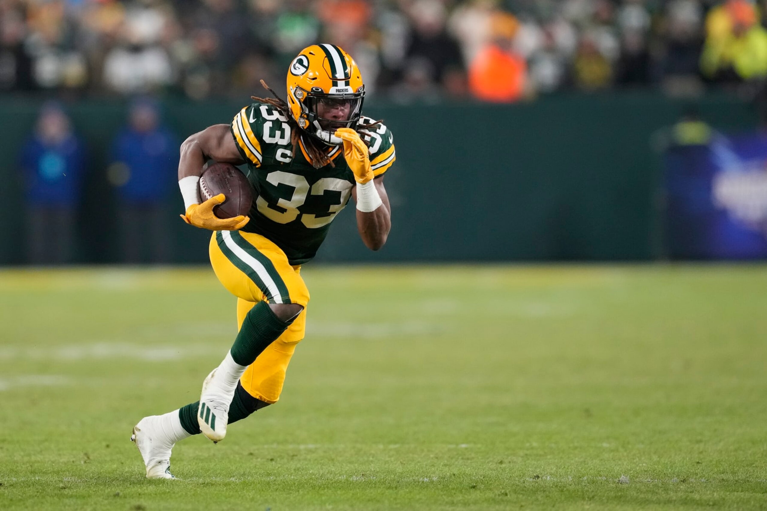 GREEN BAY, WISCONSIN - JANUARY 08: Aaron Jones #33 of the Green Bay Packers runs with the ball against the Detroit Lions in the first half at Lambeau Field on January 08, 2023 in Green Bay, Wisconsin. (Photo by Patrick McDermott/Getty Images)
