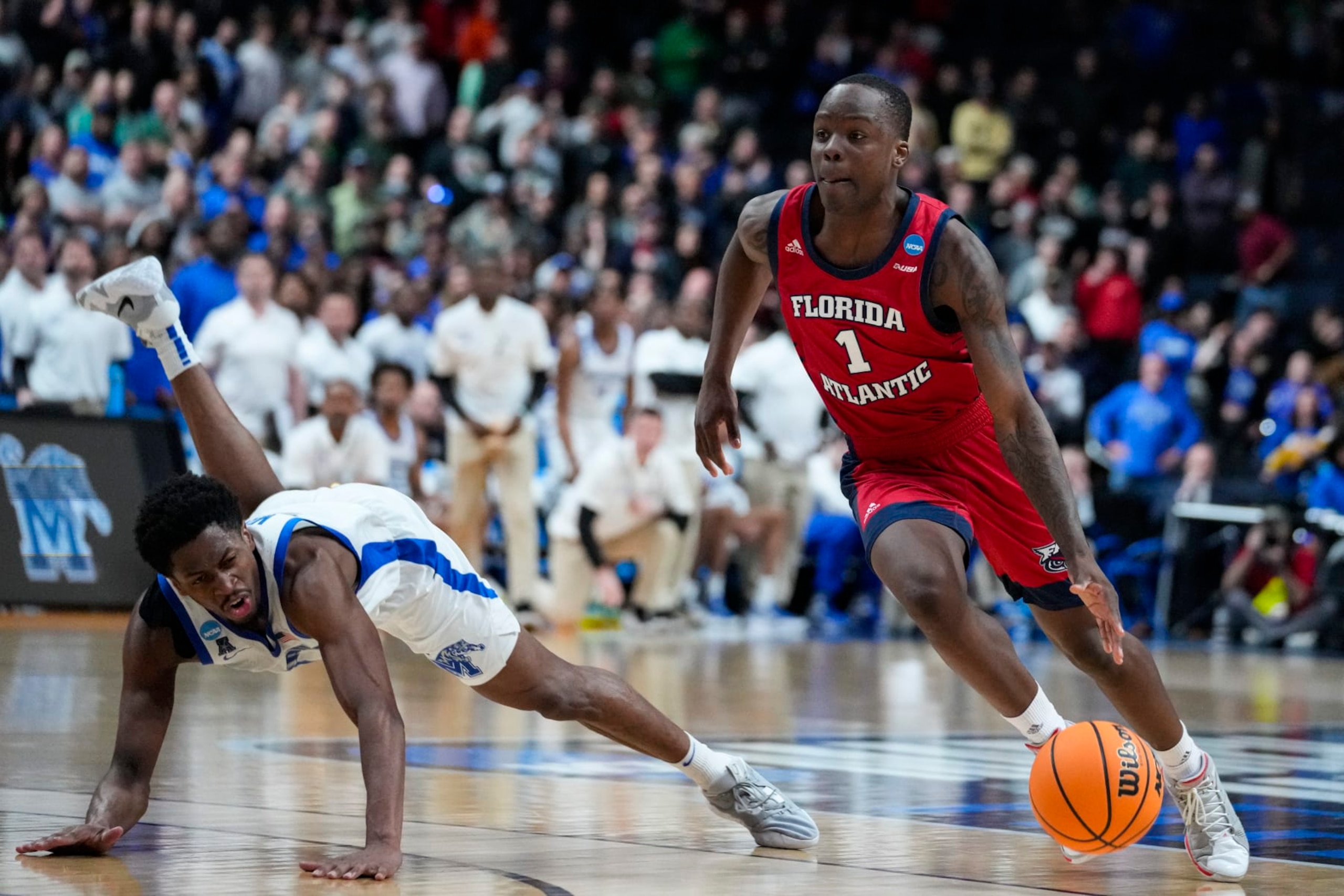 Florida Atlantic guard Johnell Davis (1) drives past Memphis guard Elijah McCadden (0) in the second half of a first-round college basketball game in the men's NCAA Tournament in Columbus, Ohio, Friday, March 17, 2023. Florida Atlantic defeated Memphis 66-65. (AP Photo/Michael Conroy)