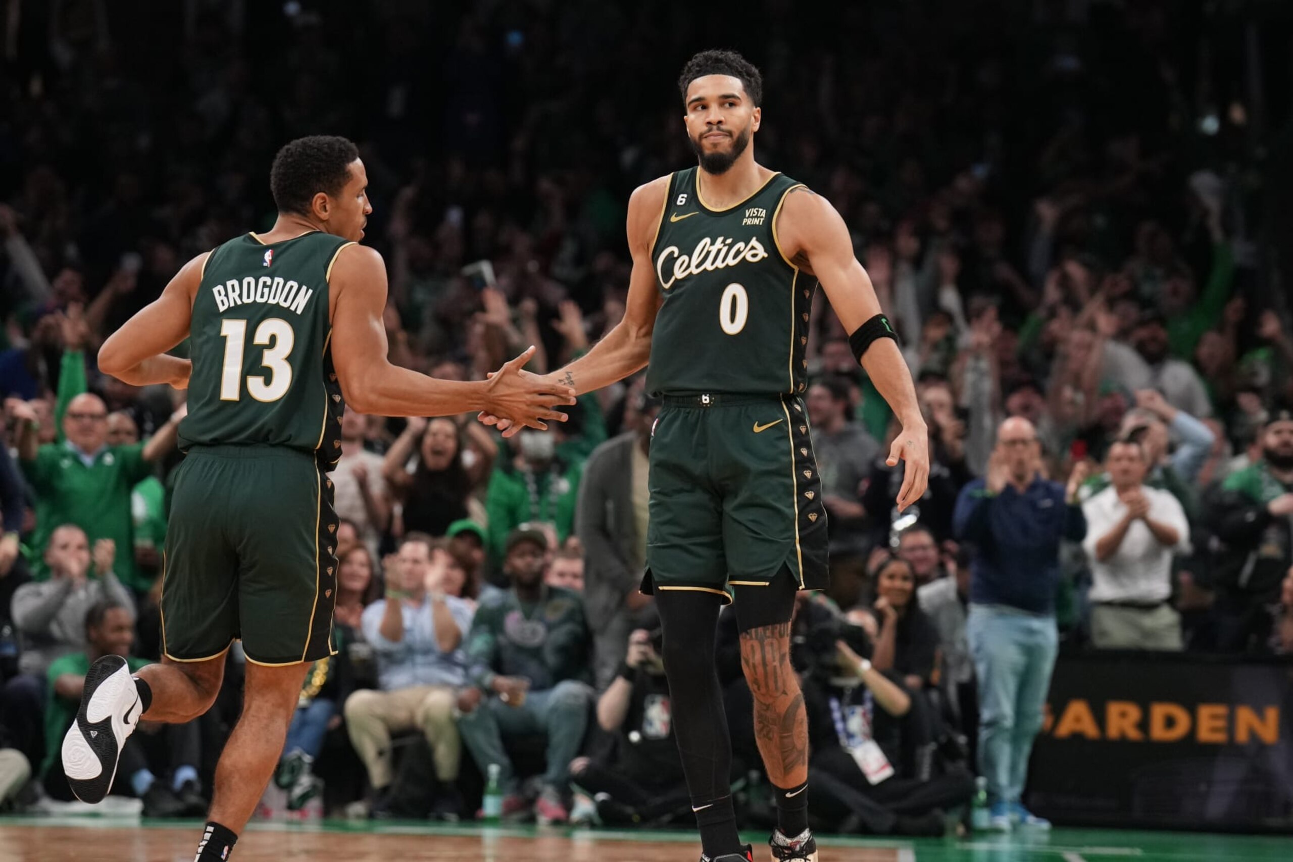 BOSTON, MA - OCTOBER 18: Malcolm Brogdon #13 high fives Jayson Tatum #0 of the Boston Celtics during the game against the Philadelphia 76ers on October 18, 2022 at the TD Garden in Boston, Massachusetts.  NOTE TO USER: User expressly acknowledges and agrees that, by downloading and or using this photograph, User is consenting to the terms and conditions of the Getty Images License Agreement. Mandatory Copyright Notice: Copyright 2022 NBAE  (Photo by Jesse D. Garrabrant/NBAE via Getty Images)