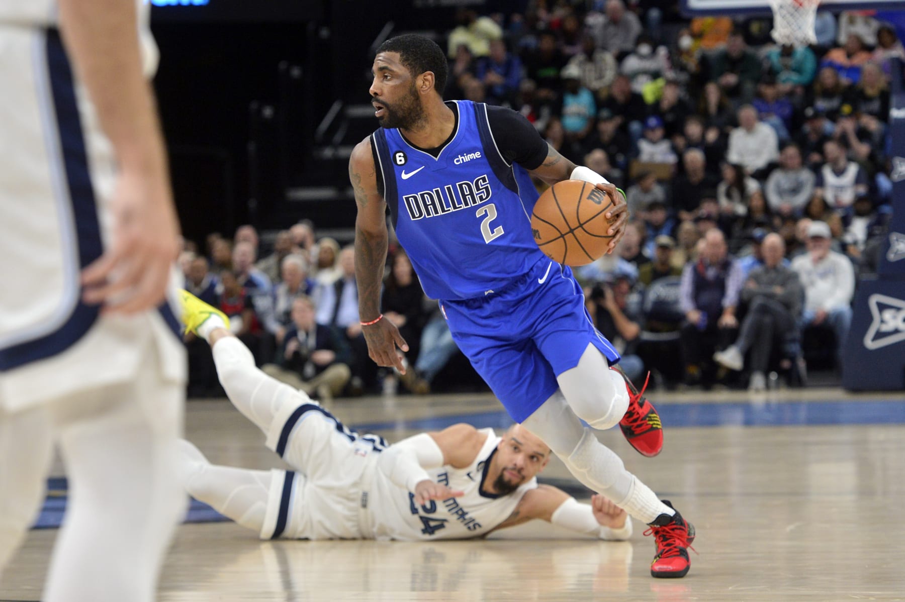 Dallas Mavericks guard Kyrie Irving (2) handles the ball as Memphis Grizzlies forward Dillon Brooks (24) falls to the floor in the first half of an NBA basketball game Monday, March 20, 2023, in Memphis, Tenn. (AP Photo/Brandon Dill)