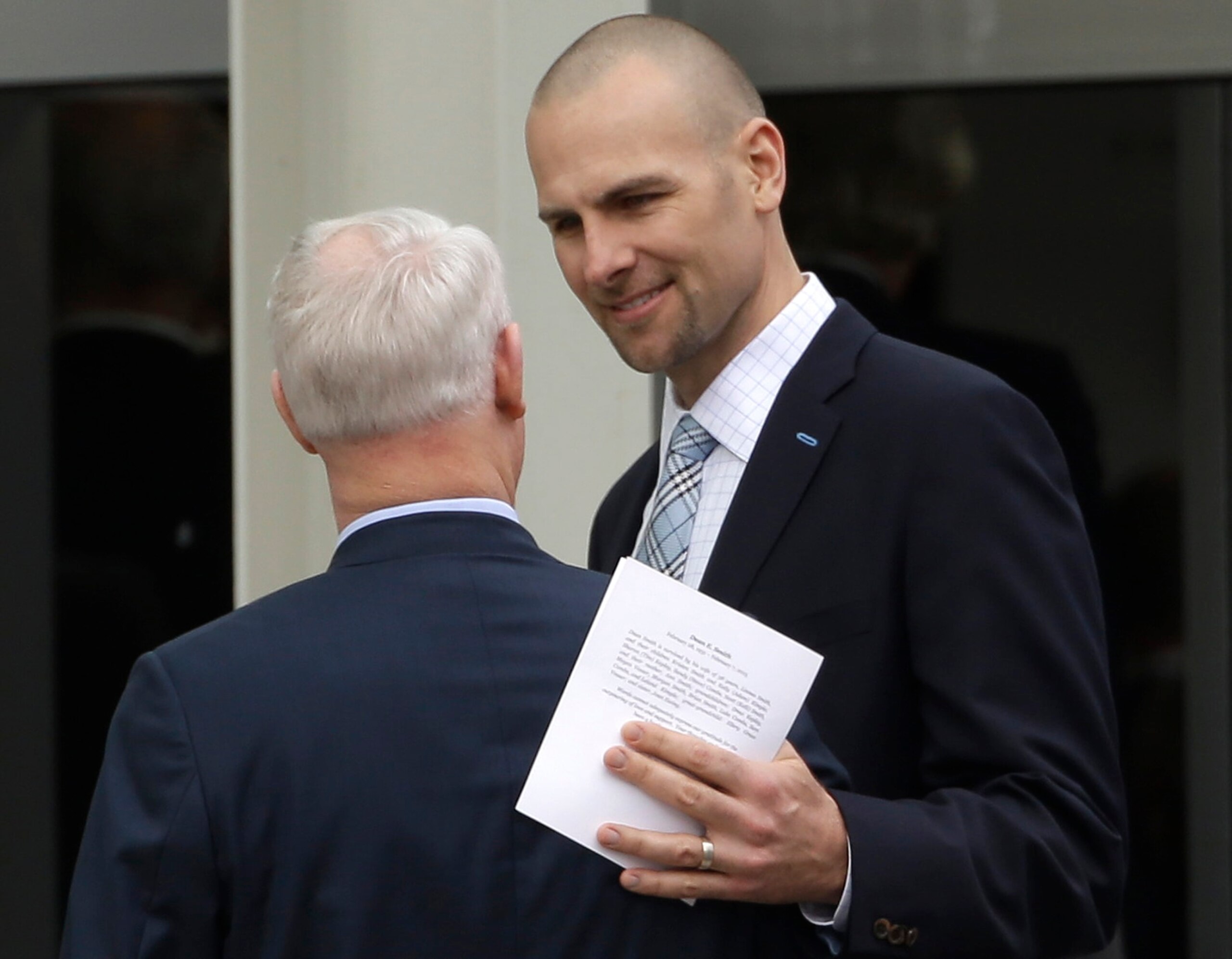 Former North Carolina basketball player Eric Montross, right, speaks with another attendee following a private church service for former North Carolina basketball coach Dean Smith in Chapel Hill, N.C., Thursday, Feb. 12, 2015. Smith died Saturday, Feb. 7, 2015. (AP Photo/Gerry Broome)