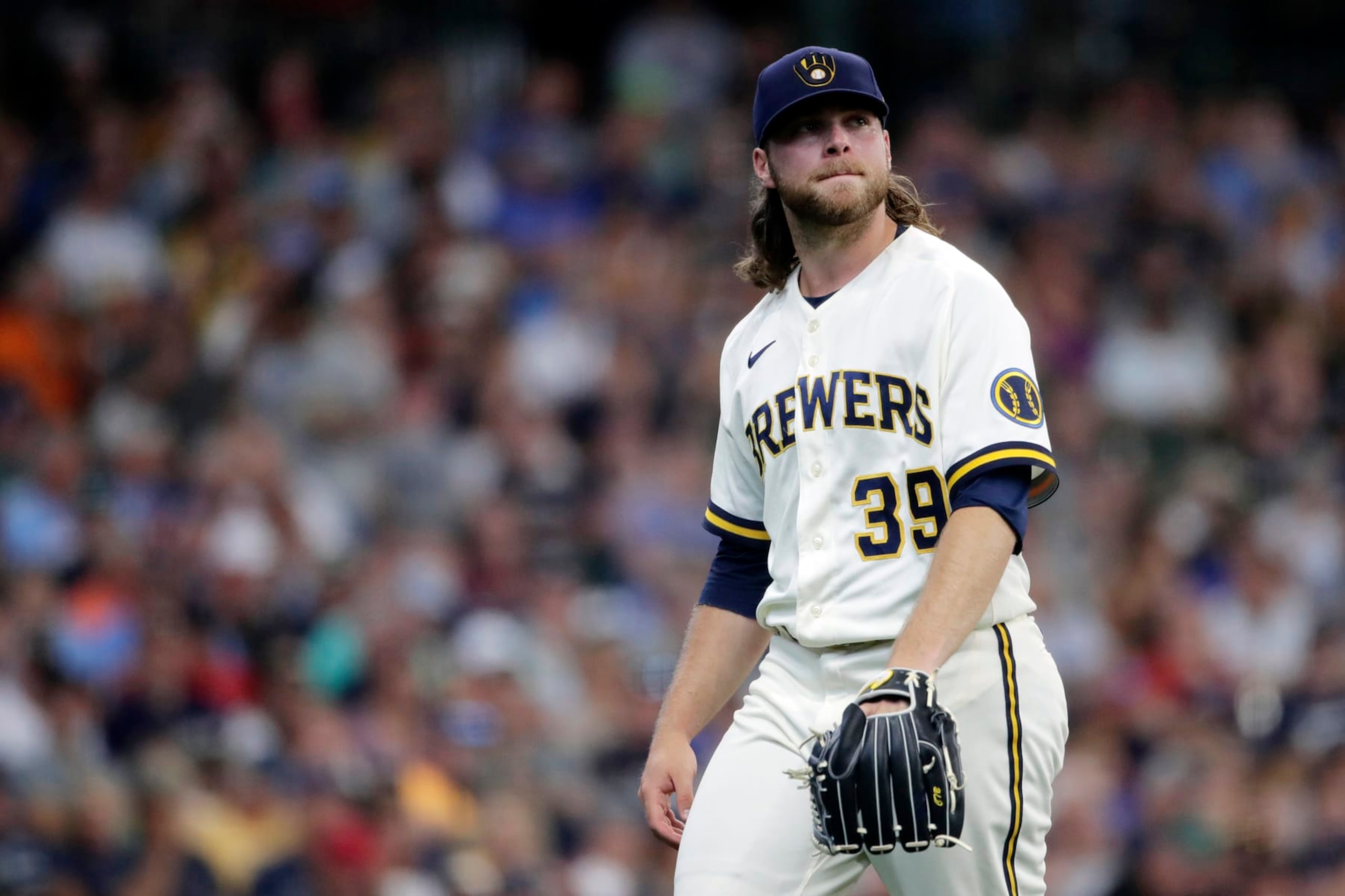 Milwaukee Brewers' Corbin Burnes reacts as he walks to the dugout during the second inning of a baseball game against the Minnesota Twins, Wednesday, July 27, 2022, in Milwaukee. (AP Photo/Aaron Gash)