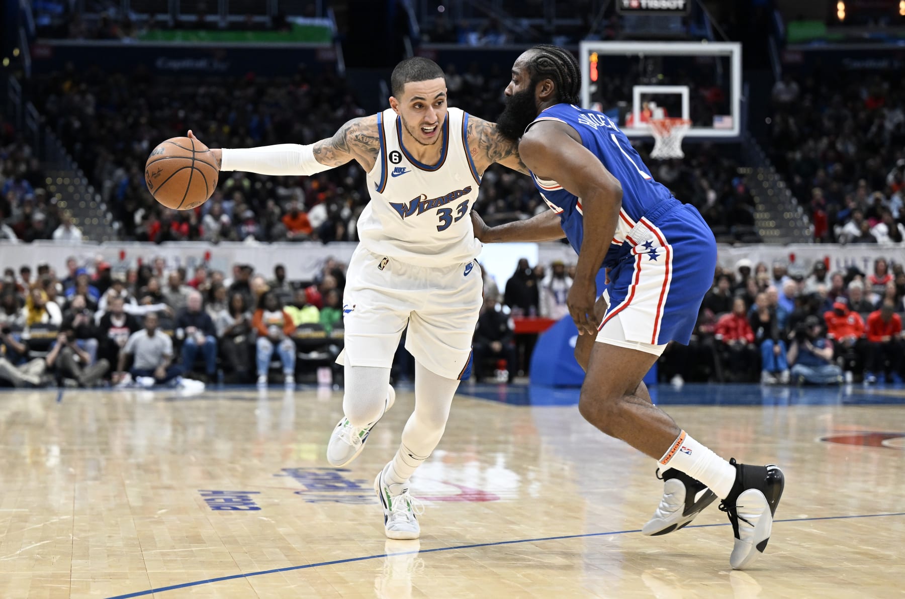 WASHINGTON, DC - DECEMBER 27: Kyle Kuzma #33 of the Washington Wizards handles the ball against James Harden #1 of the Philadelphia 76ers at Capital One Arena on December 27, 2022 in Washington, DC. NOTE TO USER: User expressly acknowledges and agrees that, by downloading and or using this photograph, User is consenting to the terms and conditions of the Getty Images License Agreement.  (Photo by G Fiume/Getty Images)