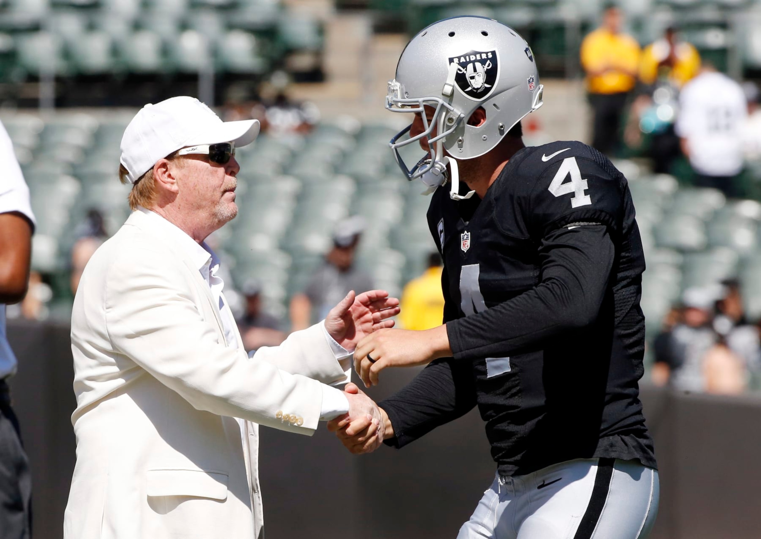 Oakland Raiders quarterback Derek Carr (4) shakes hands with team owner Mark Davis before an NFL football game against the Baltimore Ravens Sunday, Sept. 20, 2015, in Oakland , Calif. (AP Photo/Tony Avelar)