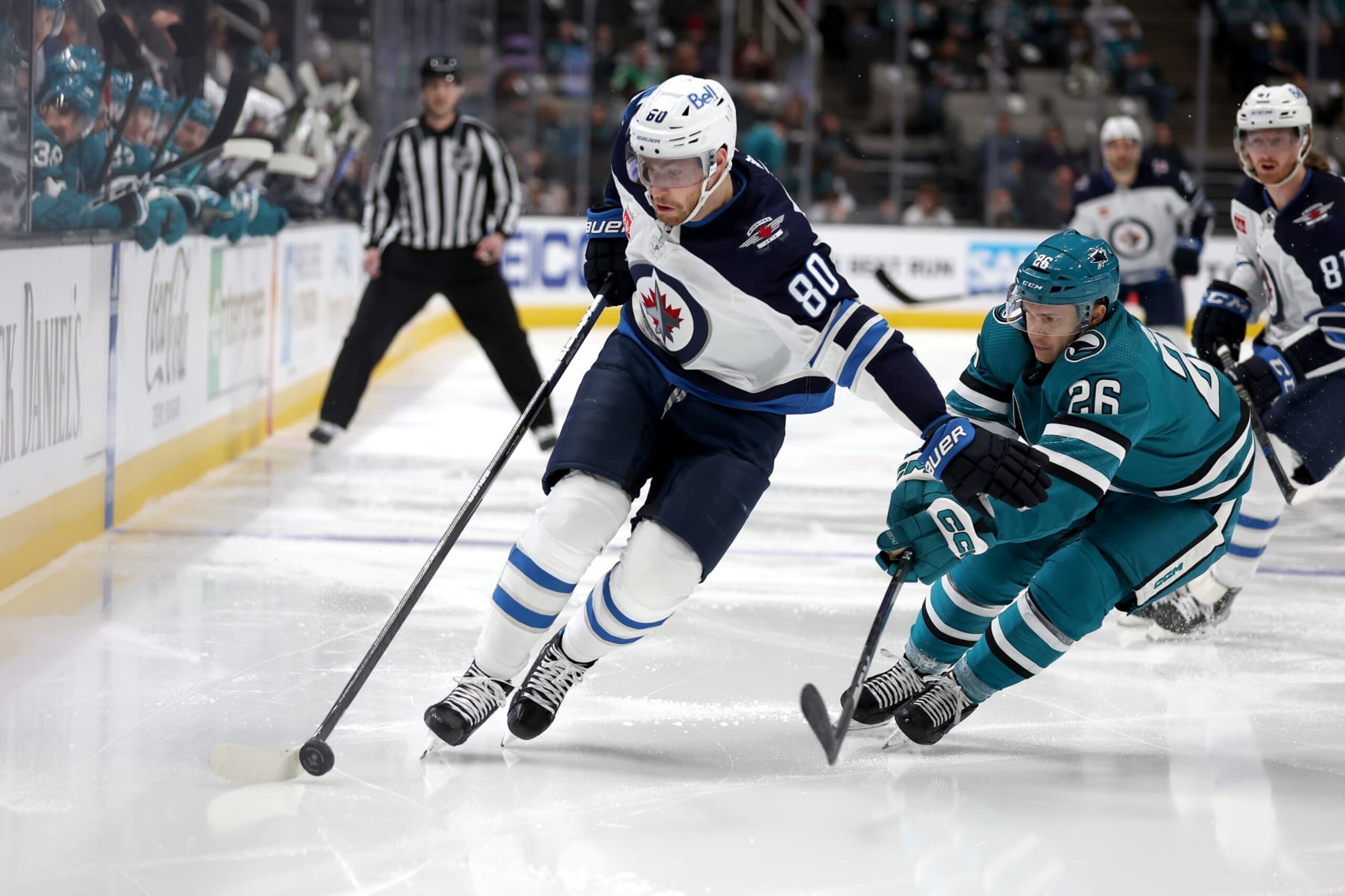 SAN JOSE, CALIFORNIA - MARCH 28: Pierre-Luc Dubois #80 of the Winnipeg Jets tries to skate away from Andrew Agozzino #26 of the San Jose Sharks in the first period at SAP Center on March 28, 2023 in San Jose, California. (Photo by Ezra Shaw/Getty Images)