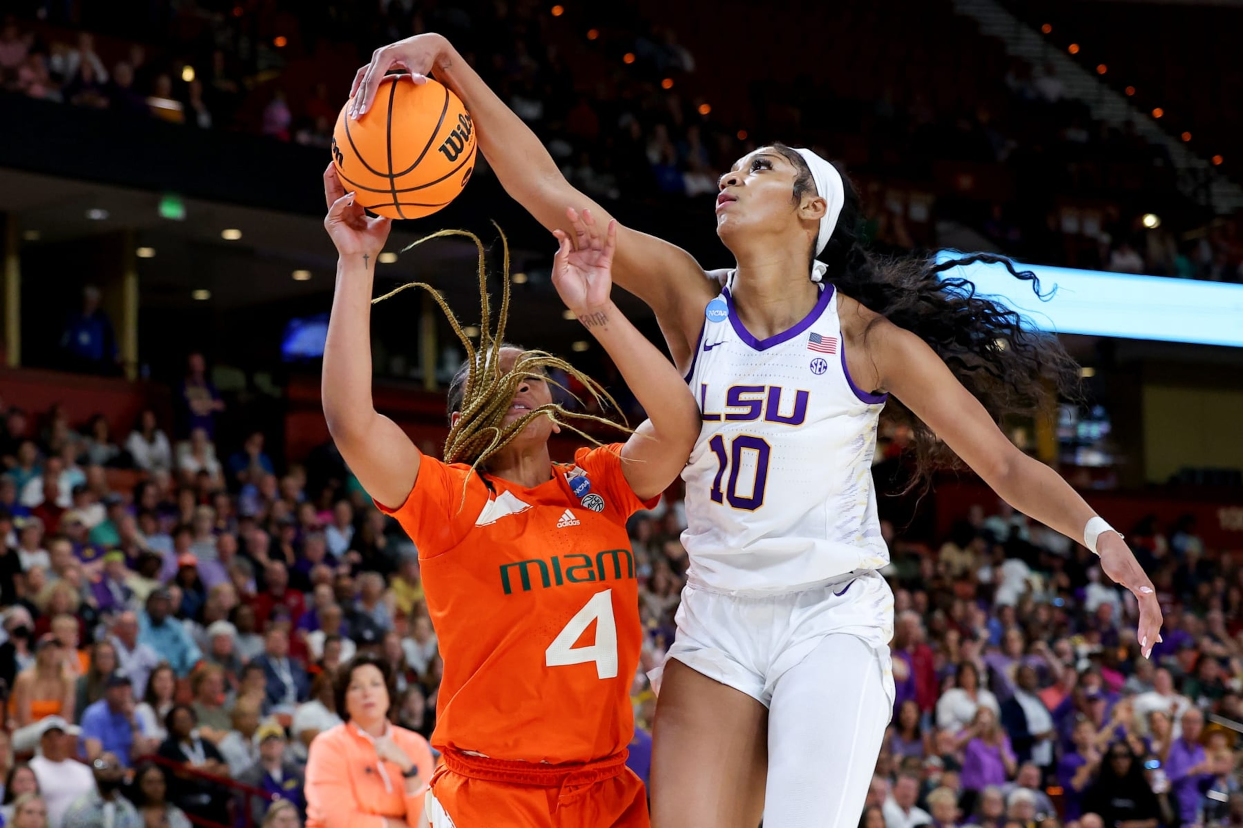 GREENVILLE, SOUTH CAROLINA - MARCH 26: Angel Reese #10 of the LSU Lady Tigers blocks a shot by Jasmyne Roberts #4 of the Miami Hurricanes during the third quarter in the Elite Eight round of the NCAA Women's Basketball Tournament at Bon Secours Wellness Arena on March 26, 2023 in Greenville, South Carolina. (Photo by Kevin C. Cox/Getty Images)