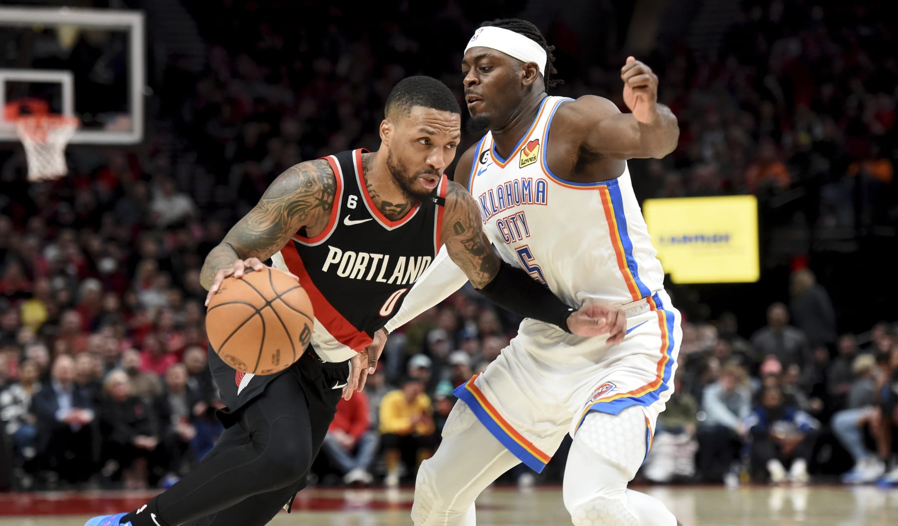 Portland Trail Blazers guard Damian Lillard, left, drives against Oklahoma City Thunder guard Luguentz Dort during the second half of an NBA basketball game in Portland, Ore., Friday, Feb. 10, 2023. The Thunder won 138-129. (AP Photo/Steve Dykes)
