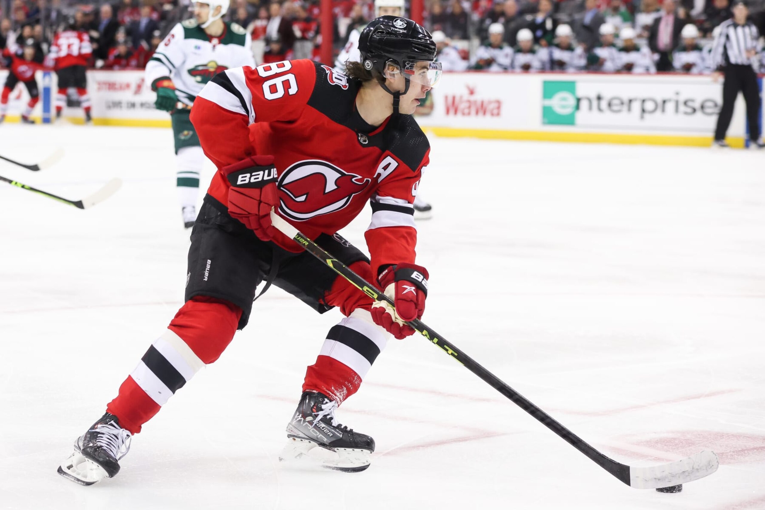 NEWARK, NJ - MARCH 21: New Jersey Devils center Jack Hughes (86) skates with the puck during the National Hockey League game between the Minnesota Wild and the New Jersey Devils on March 21, 2023 at Prudential Center in Newark, NJ. (Photo by Andrew Mordzynski/Icon Sportswire via Getty Images)
