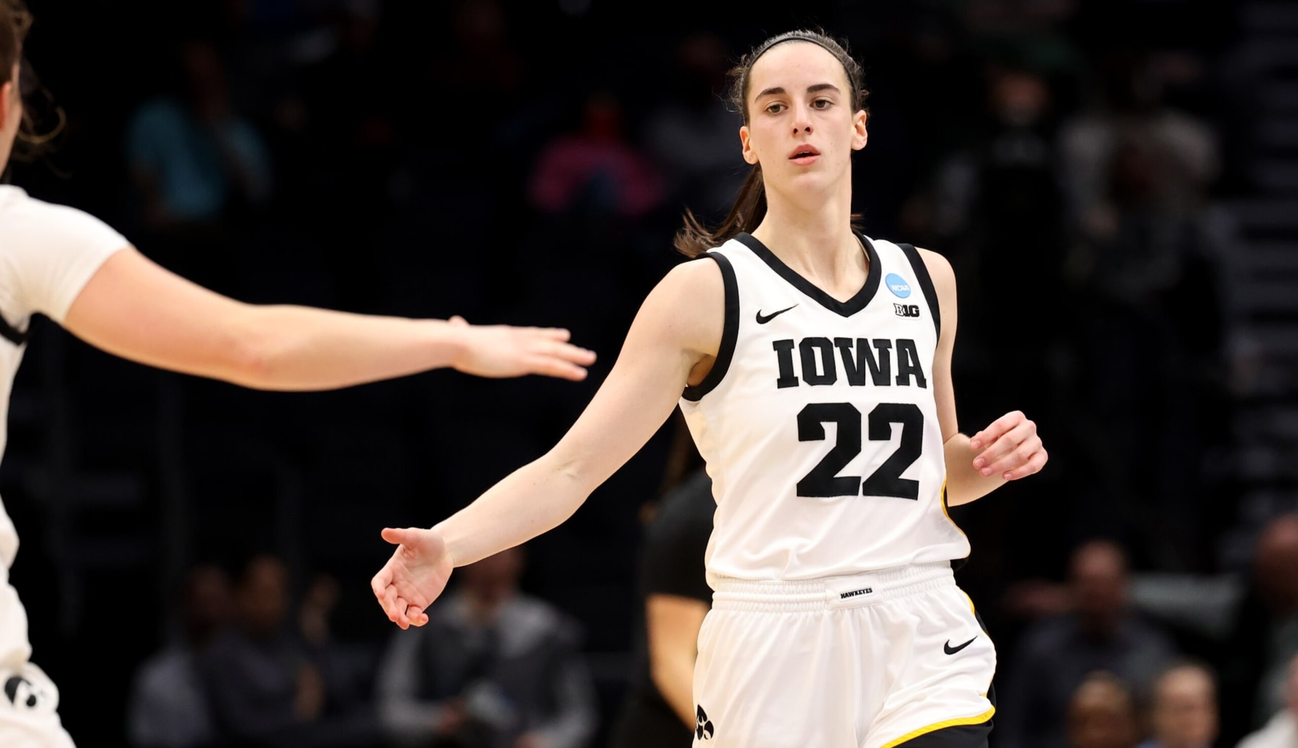 SEATTLE, WA - MARCH 26: Caitlin Clark #22 of the Iowa Hawkeyes high fives a teammate against the Louisville Cardinals during the Elite Eight round of the 2023 NCAA Women's Basketball Tournament held at Climate Pledge Arena on March 26, 2023 in Seattle, Washington. (Photo by Tyler Schank/NCAA Photos via Getty Images)