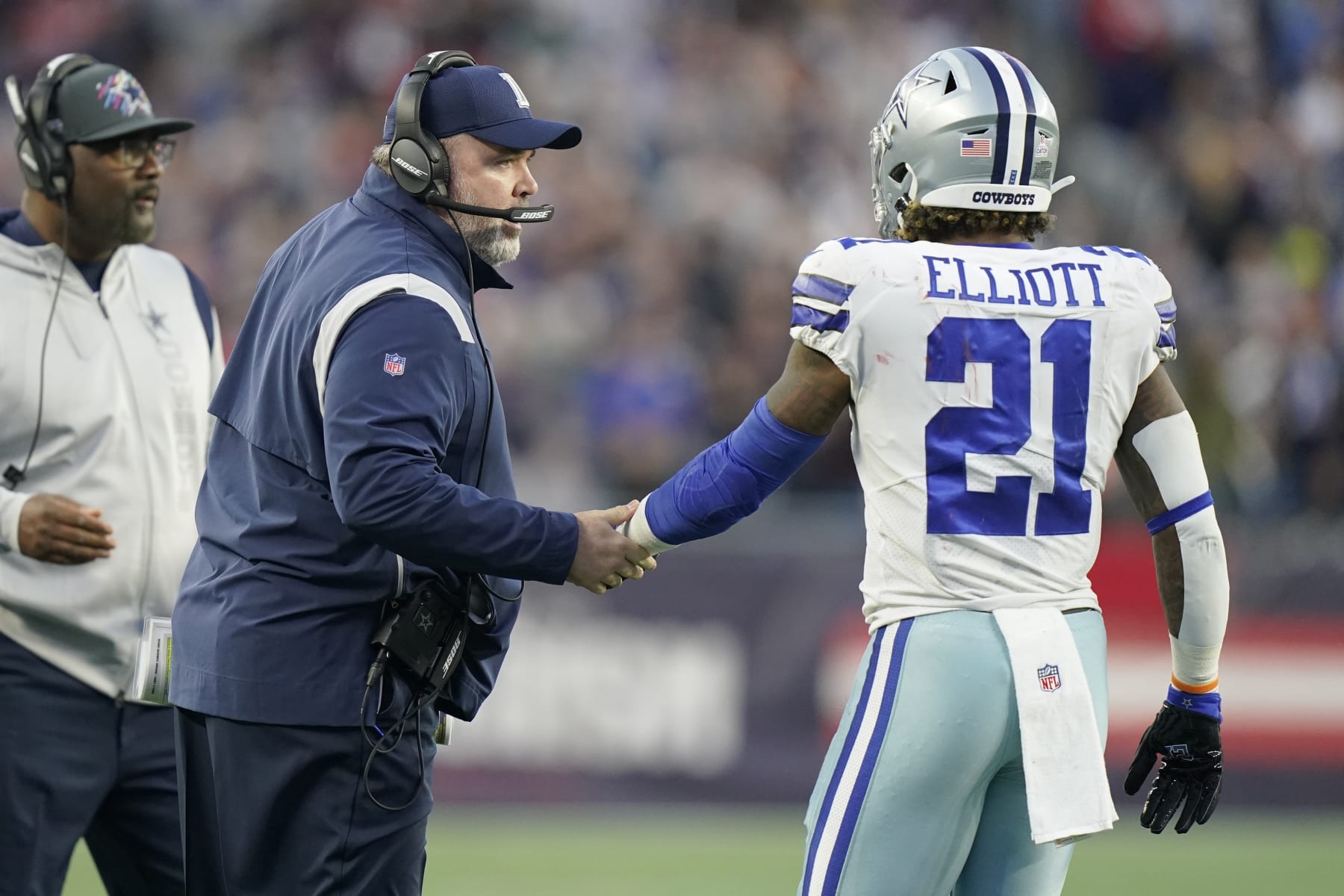 Dallas Cowboys head coach Mike McCarthy talks with running back Ezekiel Elliott (21) during the first half of an NFL football game, Sunday, Oct. 17, 2021, in Foxborough, Mass. (AP Photo/Steven Senne)