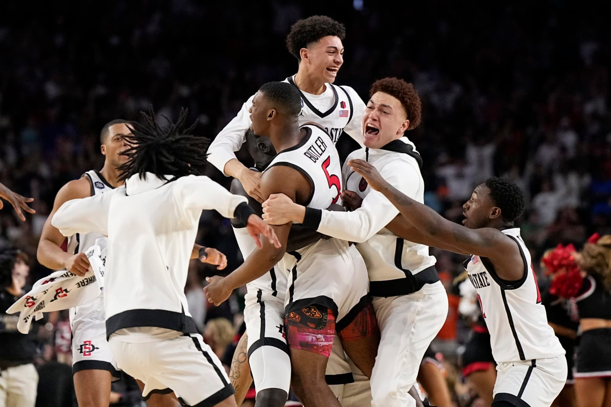 San Diego State guard Lamont Butler (5) celebrates with teammates after scoring the winning basket against Florida Atlantic during a Final Four college basketball game in the NCAA Tournament on Saturday, April 1, 2023, in Houston. (AP Photo/Brynn Anderson)