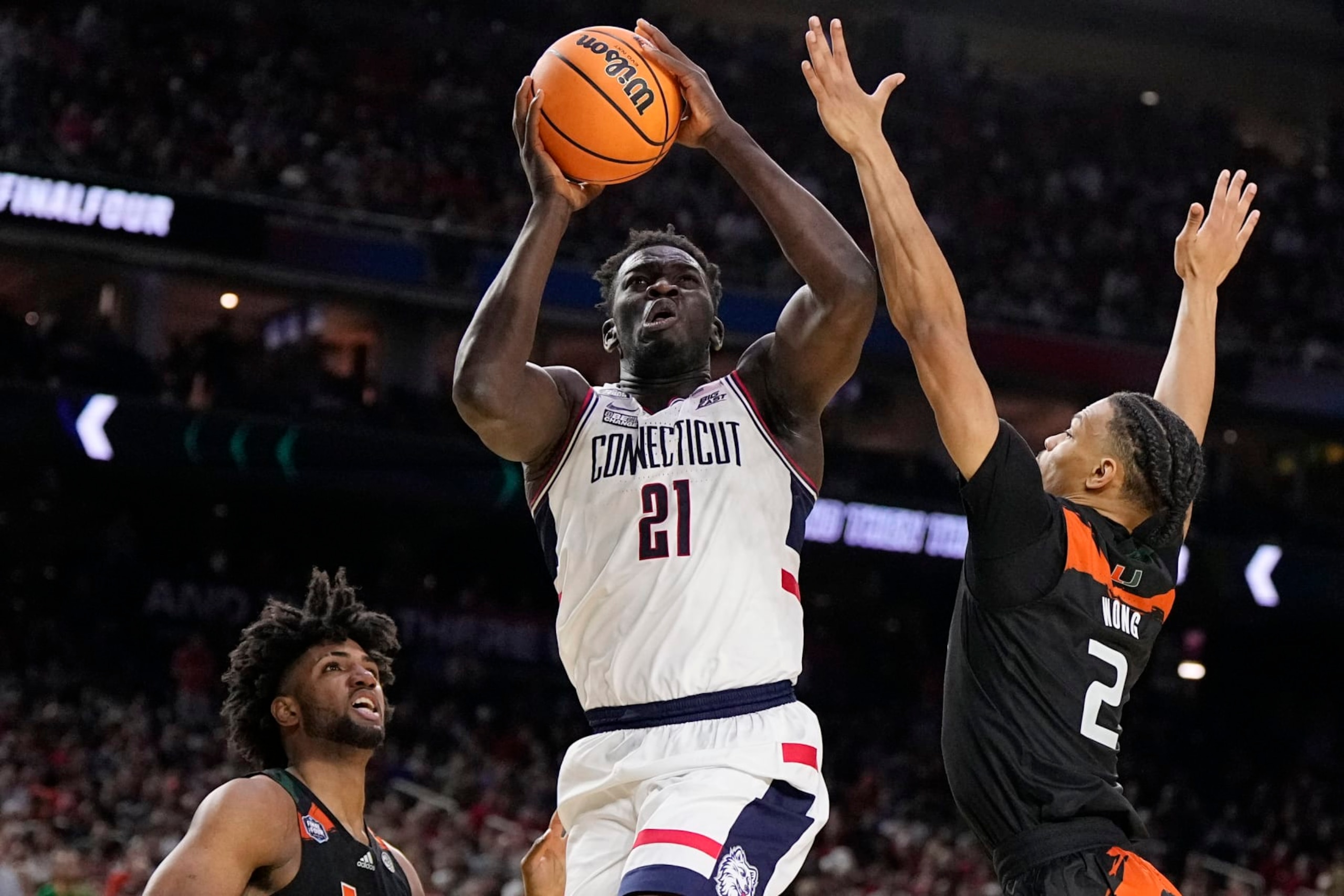 Connecticut forward Adama Sanogo scores past Miami guard Isaiah Wong during the second half of a Final Four college basketball game in the NCAA Tournament on Saturday, April 1, 2023, in Houston. (AP Photo/Brynn Anderson) Connecticut forward Adama Sanogo scores past Miami guard Isaiah Wong during the second half of a Final Four college basketball game in the NCAA Tournament on Saturday, April 1, 2023, in Houston. (AP Photo/Brynn Anderson)