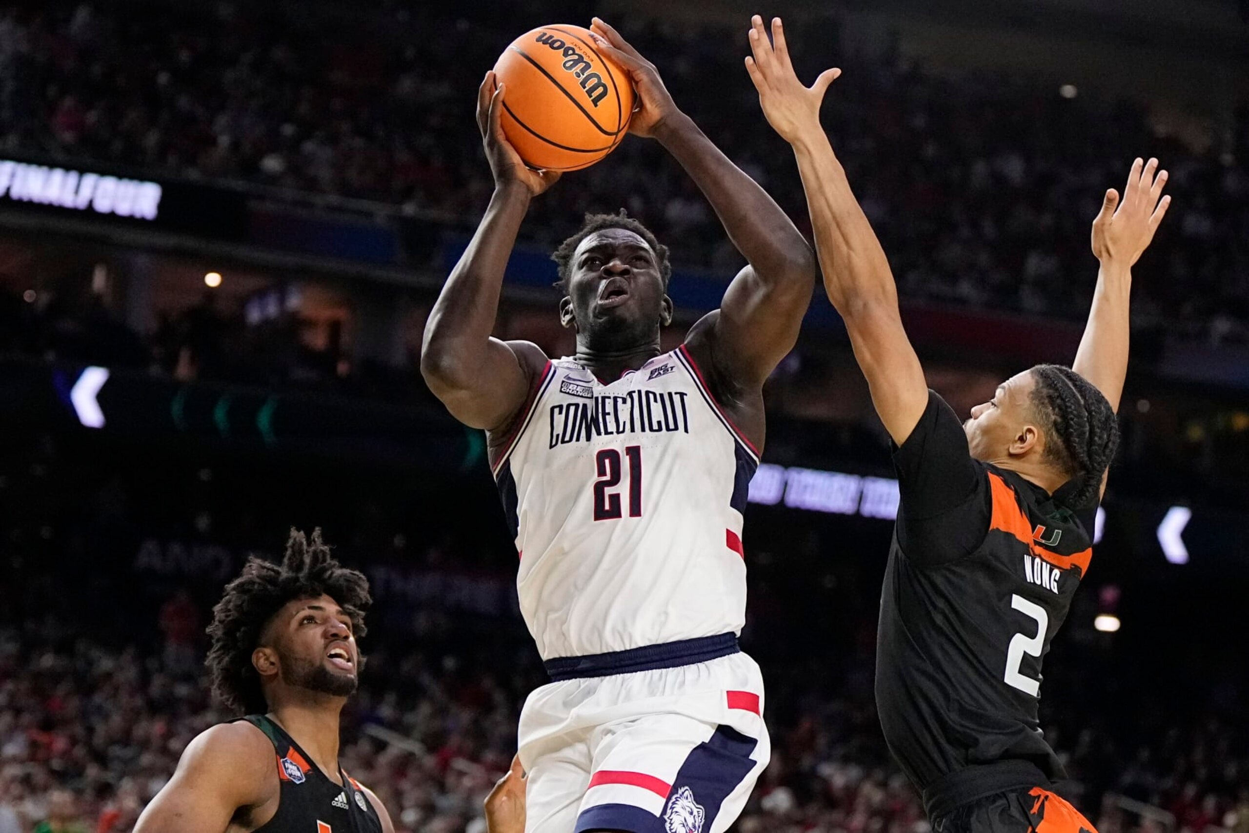 Connecticut forward Adama Sanogo scores past Miami guard Isaiah Wong during the second half of a Final Four college basketball game in the NCAA Tournament on Saturday, April 1, 2023, in Houston. (AP Photo/Brynn Anderson)
