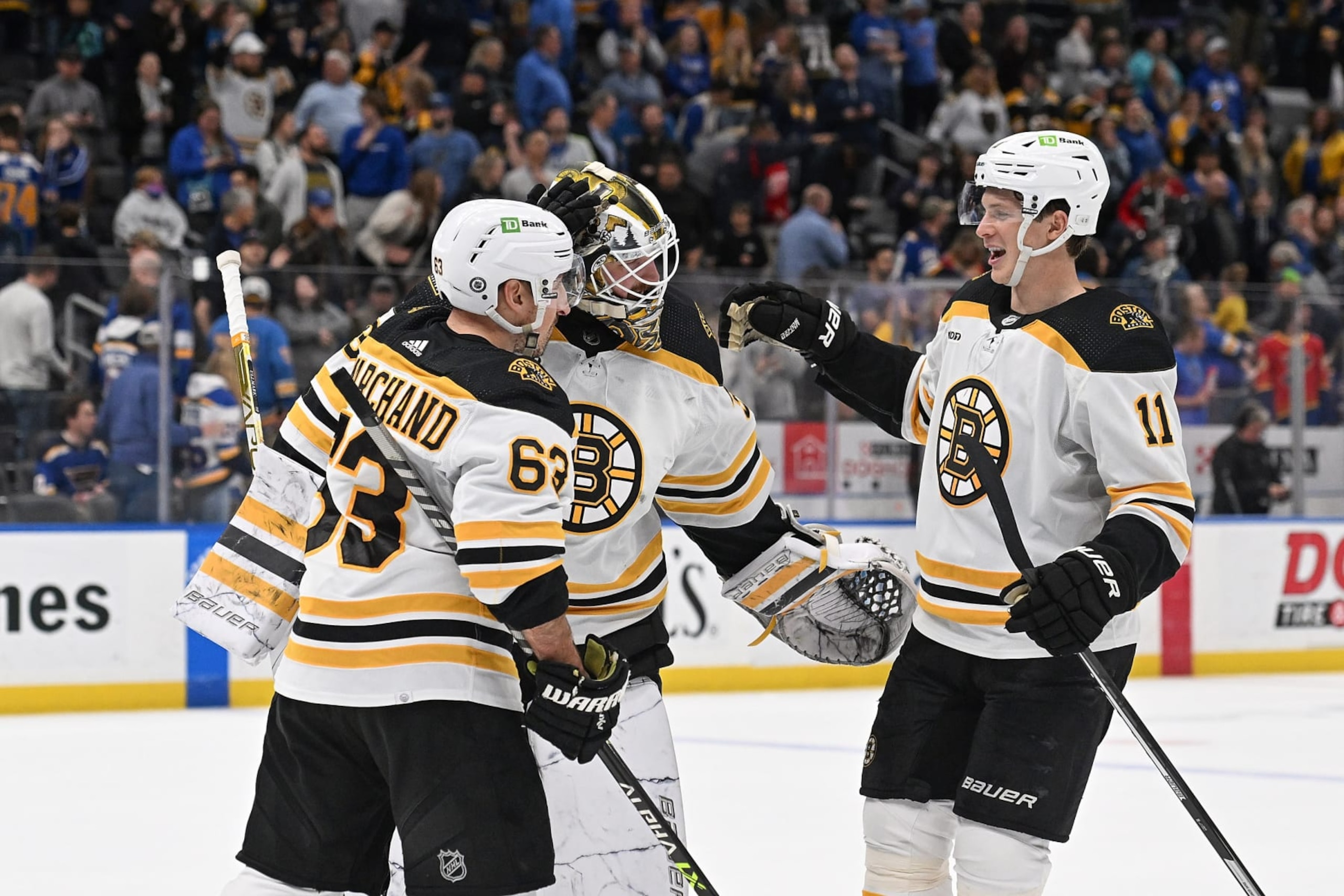 ST. LOUIS, MO - APRIL 2: Brad Marchand #63 Linus Ullmark #35 and Trent Frederic #11 of the Boston Bruins celebrate their teams victory over the St. Louis Blues in a shoot-out at the Enterprise Center on April 2, 2023 in St. Louis, Missouri. (Photo by Joe Puetz/NHLI via Getty Images)