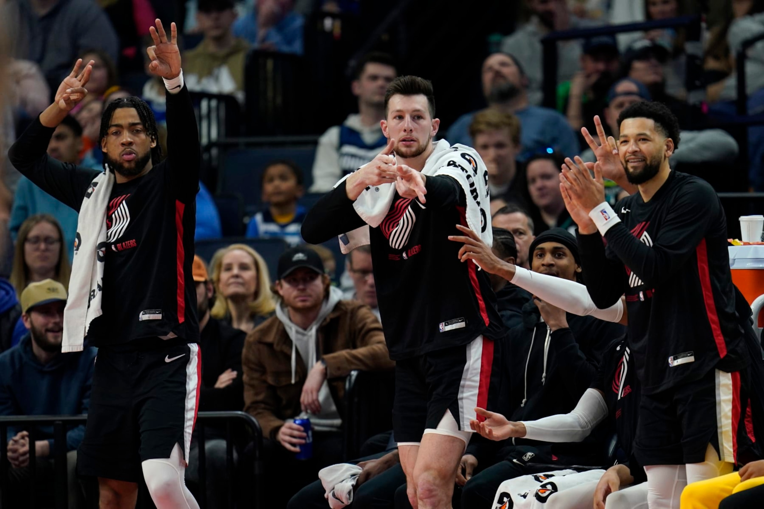Portland Trail Blazers guard Shaedon Sharpe, left, forward Drew Eubanks, middle and guard Skylar Mays celebrate from the bench during the second half of an NBA basketball game against the Minnesota Timberwolves, Sunday, April 2, 2023, in Minneapolis. (AP Photo/Abbie Parr)