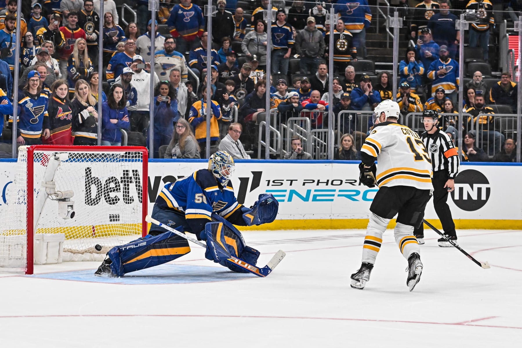 ST. LOUIS, MO - APRIL 02: Boston Bruins center Charlie Coyle (13) snaps a quick shot that goes between the legs of St. Louis Blues goaltender Jordan Binnington (50) for the game winner in shootouts during a game between the Boston Bruins and the St. Louis Blues on April 02 2023, at the Enterprise Center in St. Louis MO (Photo by Rick Ulreich/Icon Sportswire via Getty Images)