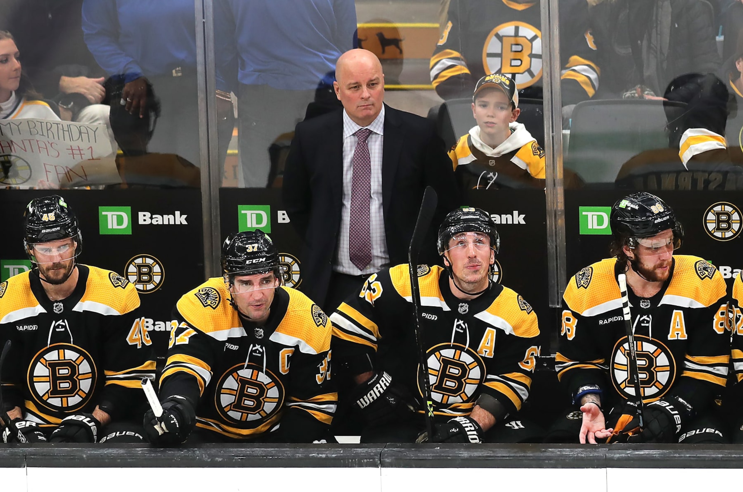 Boston, MA - January 12: Boston Bruins head coach Jim Montgomery and from left to right, David Krejci, Patrice Bergeron, Brad Marchand and David Pastrnak, look glum on the bench. The Bruins lost to the Seattle Kraken, 3-0. (Photo by John Tlumacki/The Boston Globe via Getty Images)