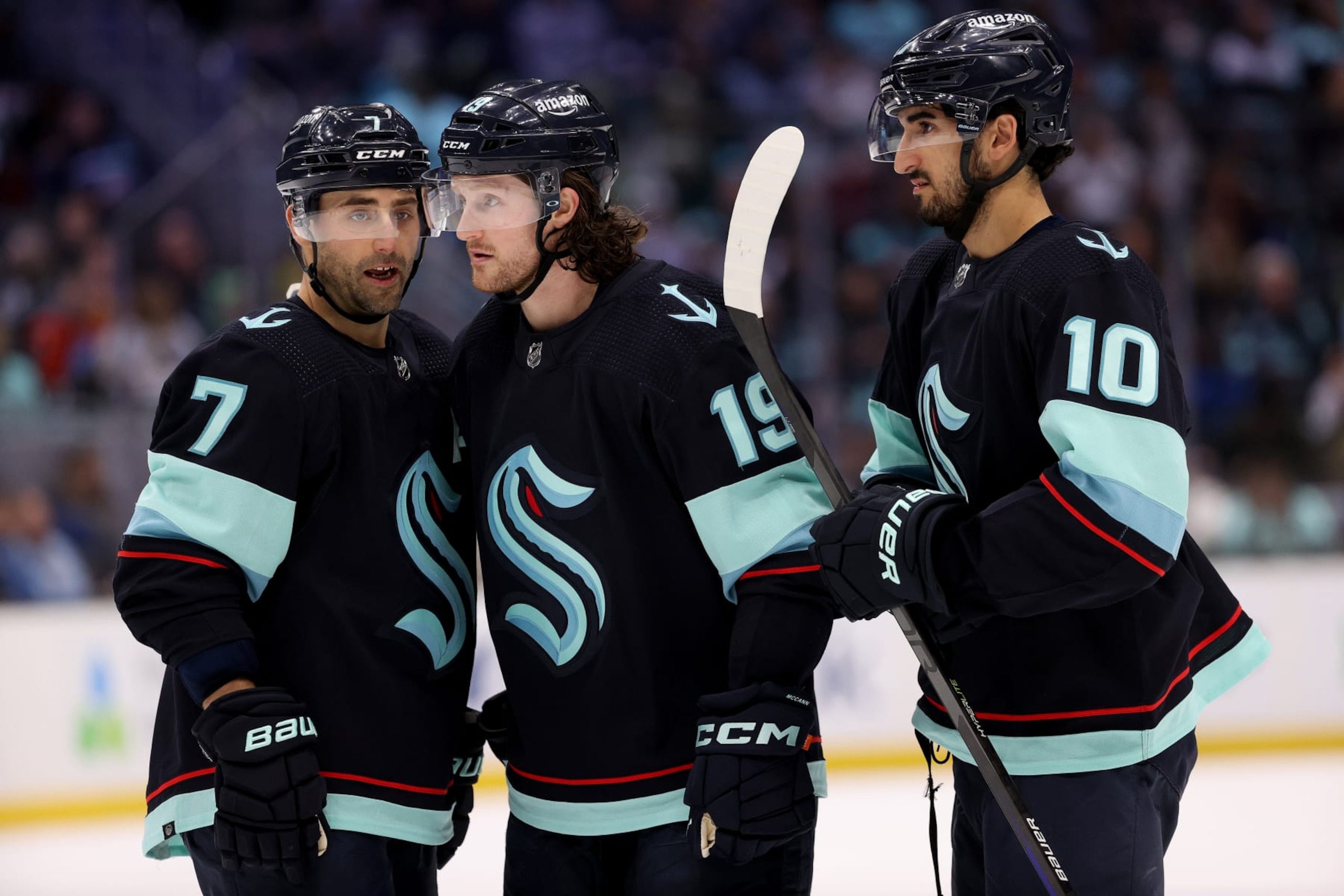 SEATTLE, WASHINGTON - APRIL 01: Jordan Eberle #7, Jared McCann #19 and Matty Beniers #10 of the Seattle Kraken talk during the second period against the Los Angeles Kings at Climate Pledge Arena on April 01, 2023 in Seattle, Washington. (Photo by Steph Chambers/Getty Images)