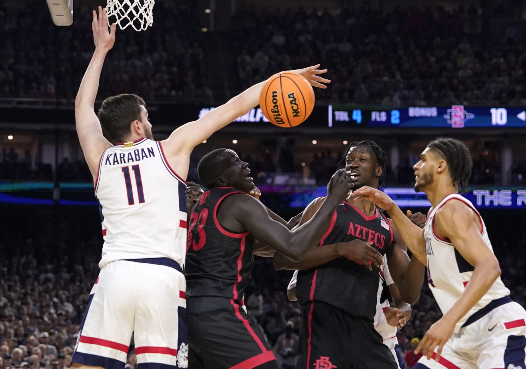 Connecticut forward Alex Karaban (11) knocks the ball away from San Diego State forward Aguek Arop (33) during the first half of the men's national championship college basketball game in the NCAA Tournament on Monday, April 3, 2023, in Houston. (AP Photo/David J. Phillip)