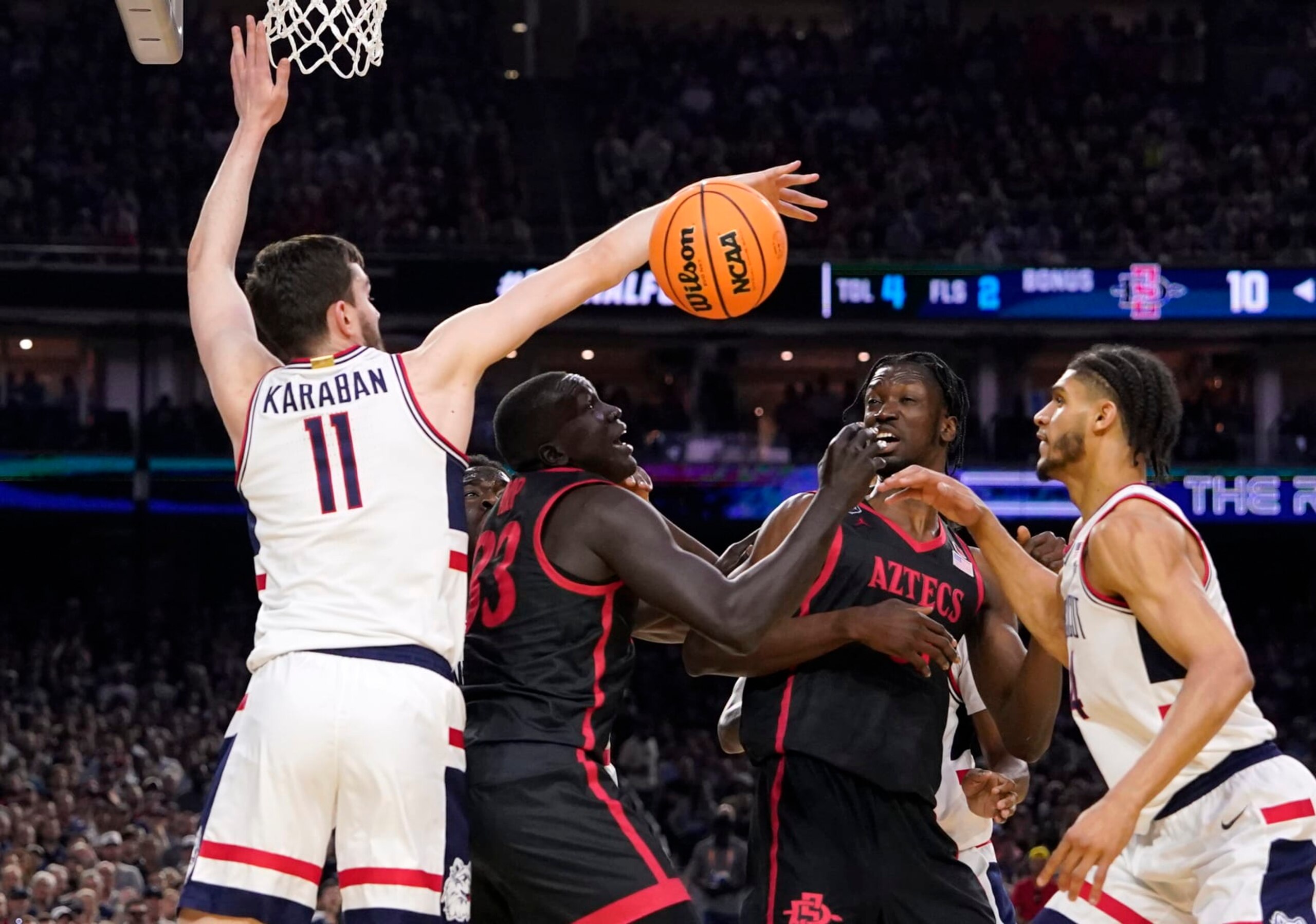 Connecticut forward Alex Karaban (11) knocks the ball away from San Diego State forward Aguek Arop (33) during the first half of the men's national championship college basketball game in the NCAA Tournament on Monday, April 3, 2023, in Houston. (AP Photo/David J. Phillip)