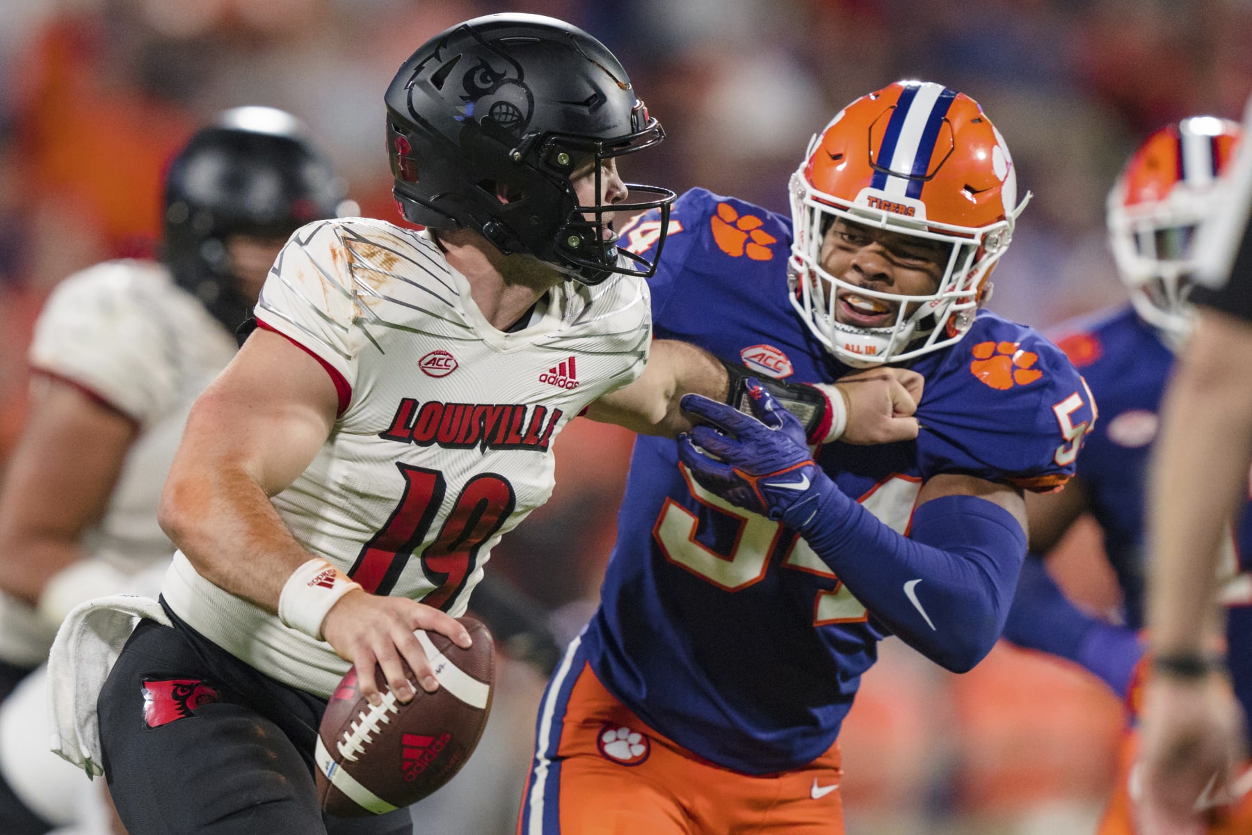 Clemson linebacker Jeremiah Trotter Jr. (54) tries to tackle Louisville quarterback Brock Domann (19) in the second half of an NCAA college football game, Saturday, Nov. 12, 2022, in Clemson, S.C. (AP Photo/Jacob Kupferman)