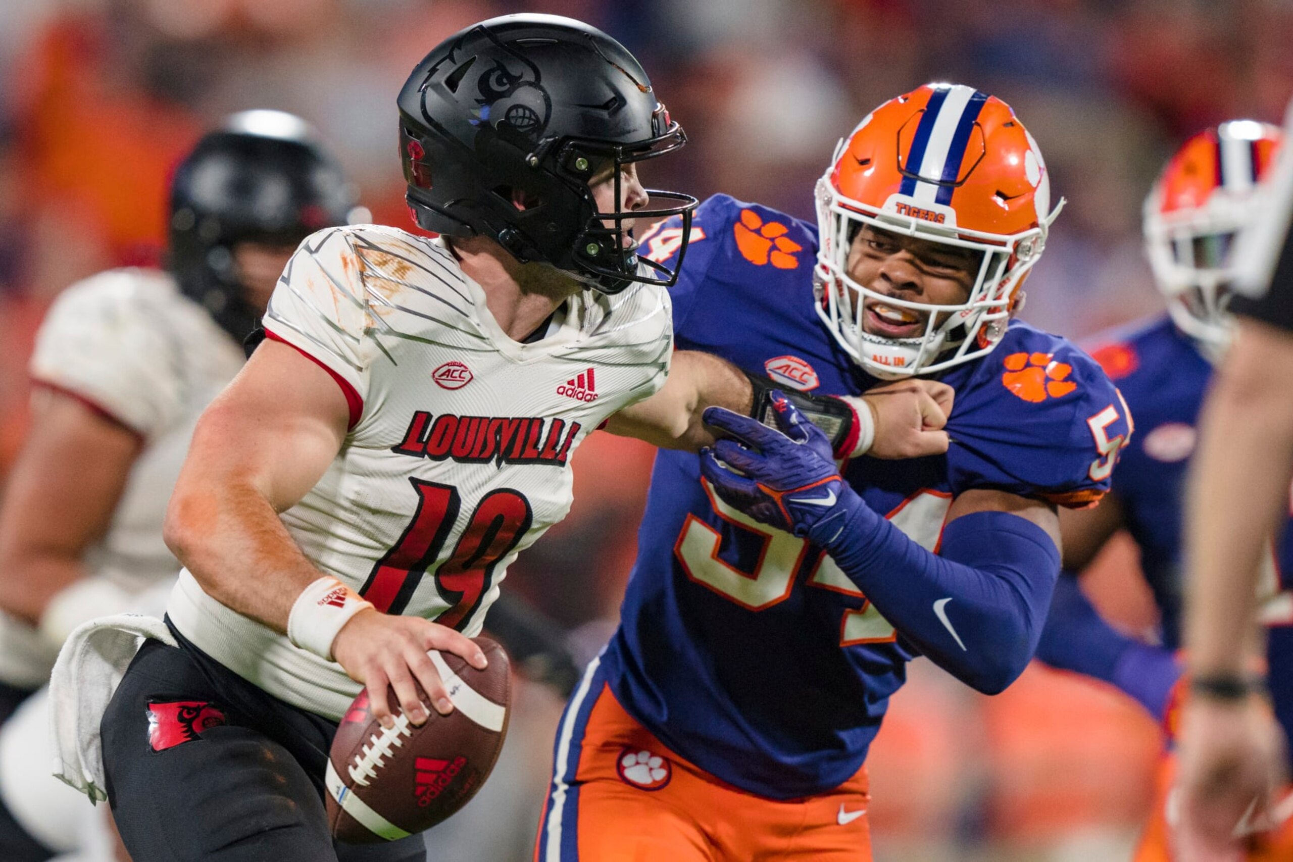 Clemson linebacker Jeremiah Trotter Jr. (54) tries to tackle Louisville quarterback Brock Domann (19) in the second half of an NCAA college football game, Saturday, Nov. 12, 2022, in Clemson, S.C. (AP Photo/Jacob Kupferman)