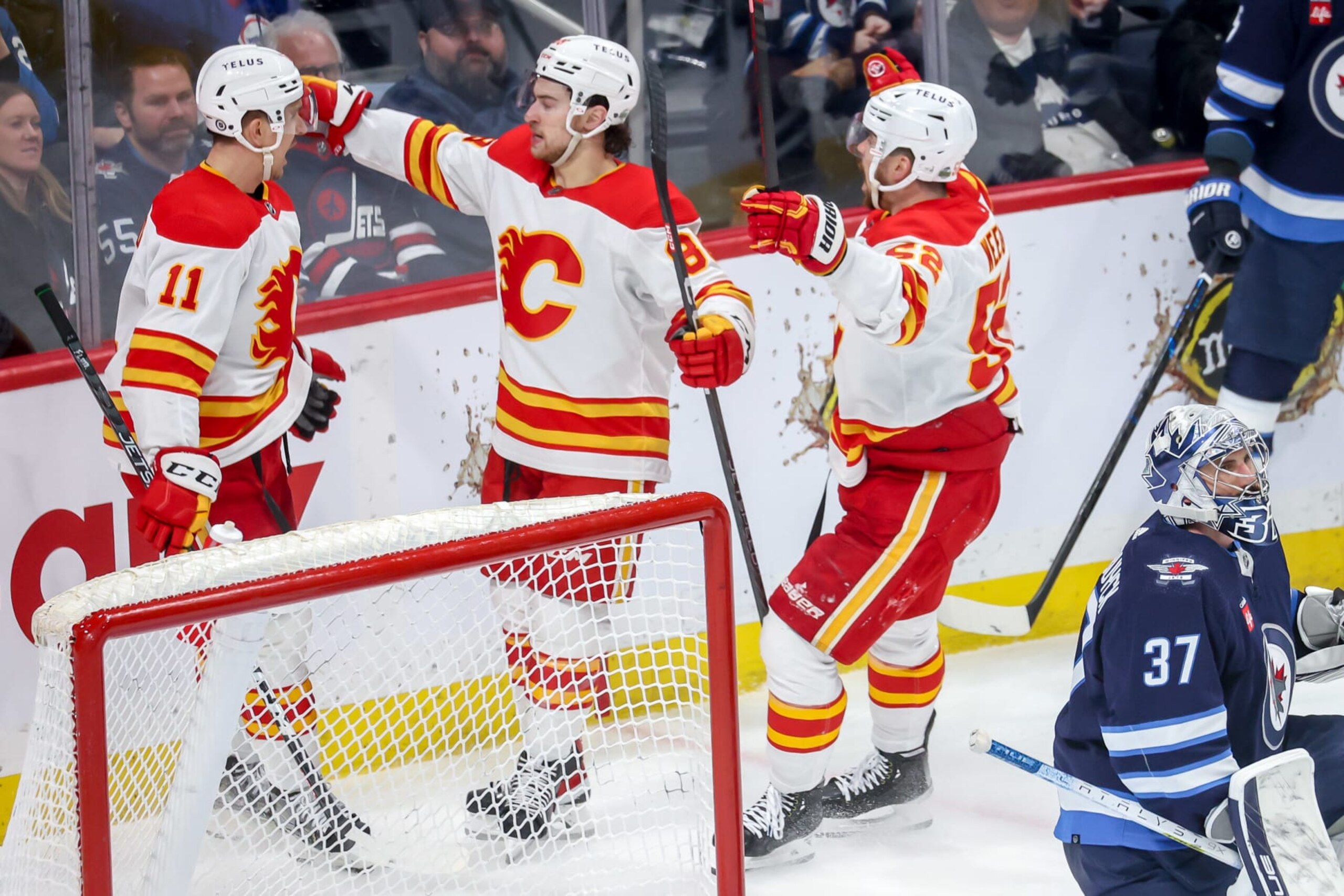 WINNIPEG, CANADA - APRIL 5: Mikael Backlund #11, Andrew Mangiapane #88 and MacKenzie Weegar #52 of the Calgary Flames celebrate a second period goal against the Winnipeg Jets at the Canada Life Centre on April 5, 2023 in Winnipeg, Manitoba, Canada. (Photo by Jonathan Kozub/NHLI via Getty Images) WINNIPEG, CANADA - APRIL 5: Mikael Backlund #11, Andrew Mangiapane #88 and MacKenzie Weegar #52 of the Calgary Flames celebrate a second period goal against the Winnipeg Jets at the Canada Life Centre on April 5, 2023 in Winnipeg, Manitoba, Canada. (Photo by Jonathan Kozub/NHLI via Getty Images)