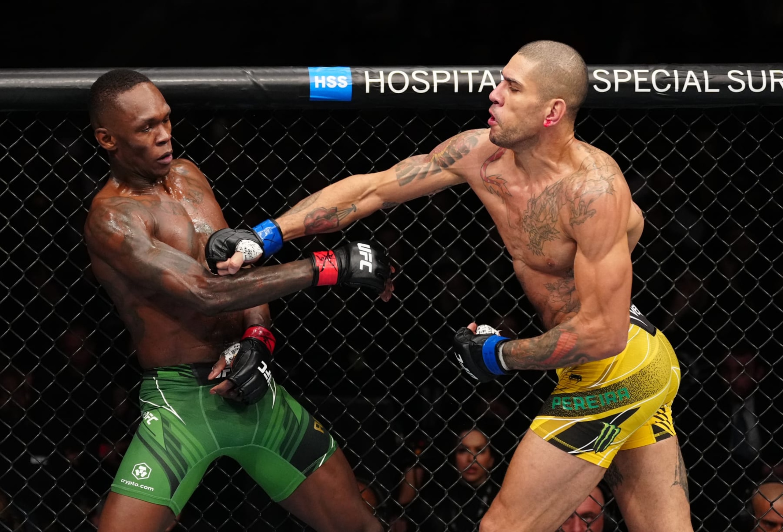 Alex Pereira (right) throws a punch at Israel Adesanya