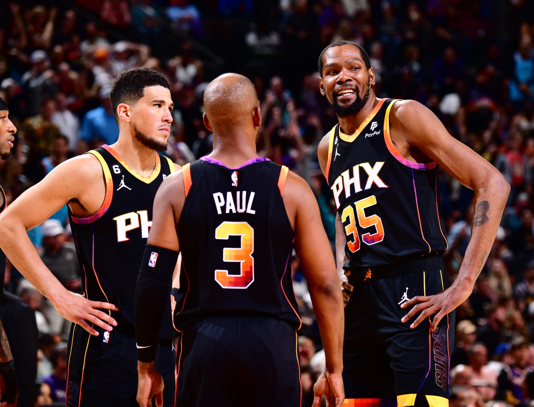 PHOENIX, AZ - APRIL 6:  Devin Booker #1, Chris Paul #3 and Kevin Durant #35 of the Phoenix Suns looks on during the game on April 6, 2023 at Footprint Center in Phoenix, Arizona. NOTE TO USER: User expressly acknowledges and agrees that, by downloading and or using this photograph, user is consenting to the terms and conditions of the Getty Images License Agreement. Mandatory Copyright Notice: Copyright 2023 NBAE (Photo by Barry Gossage/NBAE via Getty Images)