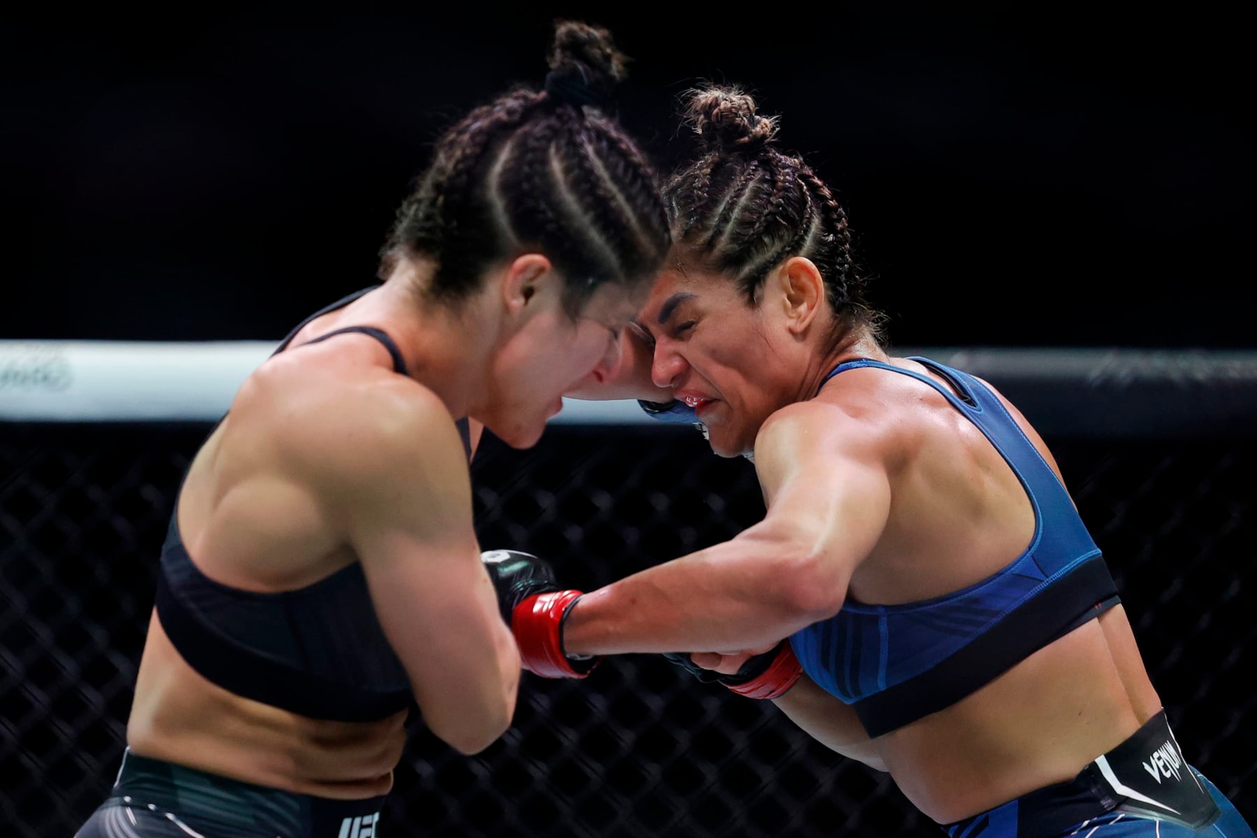 MIAMI, FLORIDA - APRIL 08: Loopy Godinez (L) of Mexico exchanges strikes with Cynthia Calvillo in their strawweight bout during UFC 287 at Kaseya Center on April 08, 2023 in Miami, Florida. (Photo by Carmen Mandato/Getty Images)