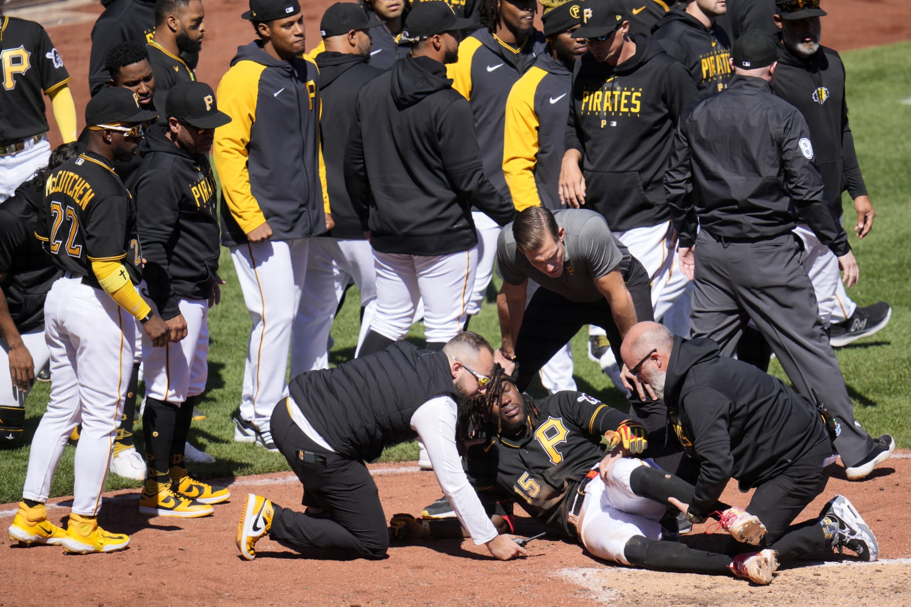 Pittsburgh Pirates' Oneil Cruz (15) is tended to by team trainers after colliding with Chicago White Sox catcher Seby Zavala attempting to score during the sixth inning of a baseball game in Pittsburgh, Sunday, April 9, 2023. A bench clearing brawl ensued as a result of the play. The Pirates won 1-0. (AP Photo/Gene J. Puskar)