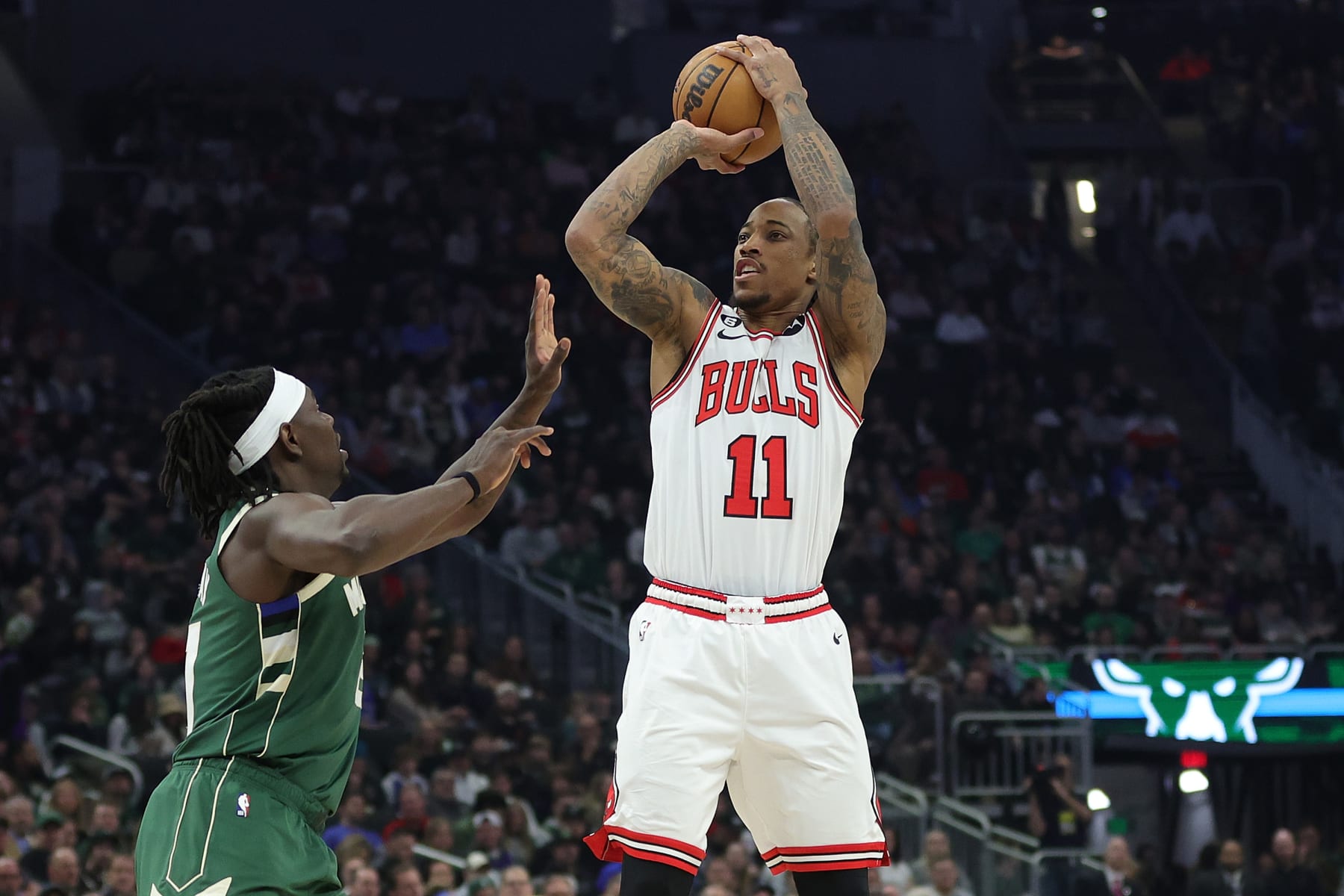MILWAUKEE, WISCONSIN - APRIL 05: DeMar DeRozan #11 of the Chicago Bulls shoots over Jrue Holiday #21 of the Milwaukee Bucks during the first half of a game at Fiserv Forum on April 05, 2023 in Milwaukee, Wisconsin. NOTE TO USER: User expressly acknowledges and agrees that, by downloading and or using this photograph, User is consenting to the terms and conditions of the Getty Images License Agreement. (Photo by Stacy Revere/Getty Images)