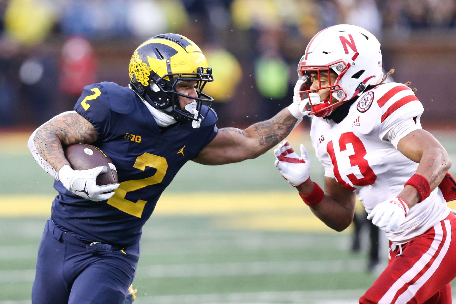 ANN ARBOR, MI - NOVEMBER 12:  Michigan Wolverines running back Blake Corum (2) runs with the ball while stiff-arming Nebraska Cornhuskers defensive back Malcolm Hartzog (13) during a regular season Big Ten Conference college football game between the Nebraska Cornhuskers and the Michigan Wolverines on November 12, 2022 at Michigan Stadium in Ann Arbor, Michigan.  (Photo by Scott W. Grau/Icon Sportswire via Getty Images)