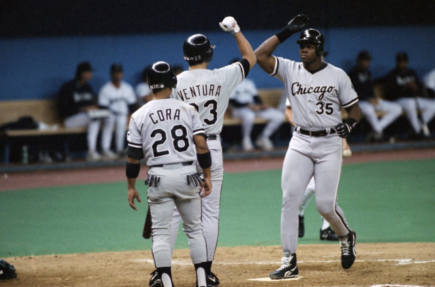 Frank Thomas (35) of the Chicago White Sox crosses home plate after collecting his 27th home run of the season, July 31, 1993 in the third inning in Seattle off pitcher Erik Hanson of the Mariners. Greeting Thomas are teammates Joey Cora (28) and Robin Ventura (23). (AP Photo/Gary Stewart)