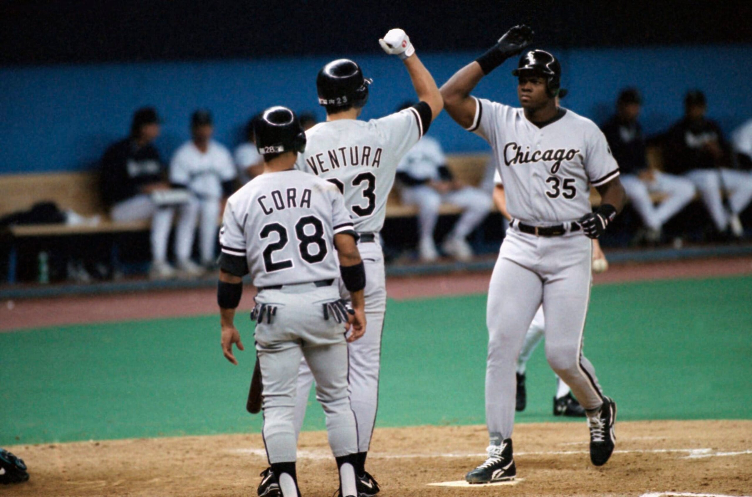 Frank Thomas (35) of the Chicago White Sox crosses home plate after collecting his 27th home run of the season, July 31, 1993 in the third inning in Seattle off pitcher Erik Hanson of the Mariners. Greeting Thomas are teammates Joey Cora (28) and Robin Ventura (23). (AP Photo/Gary Stewart)