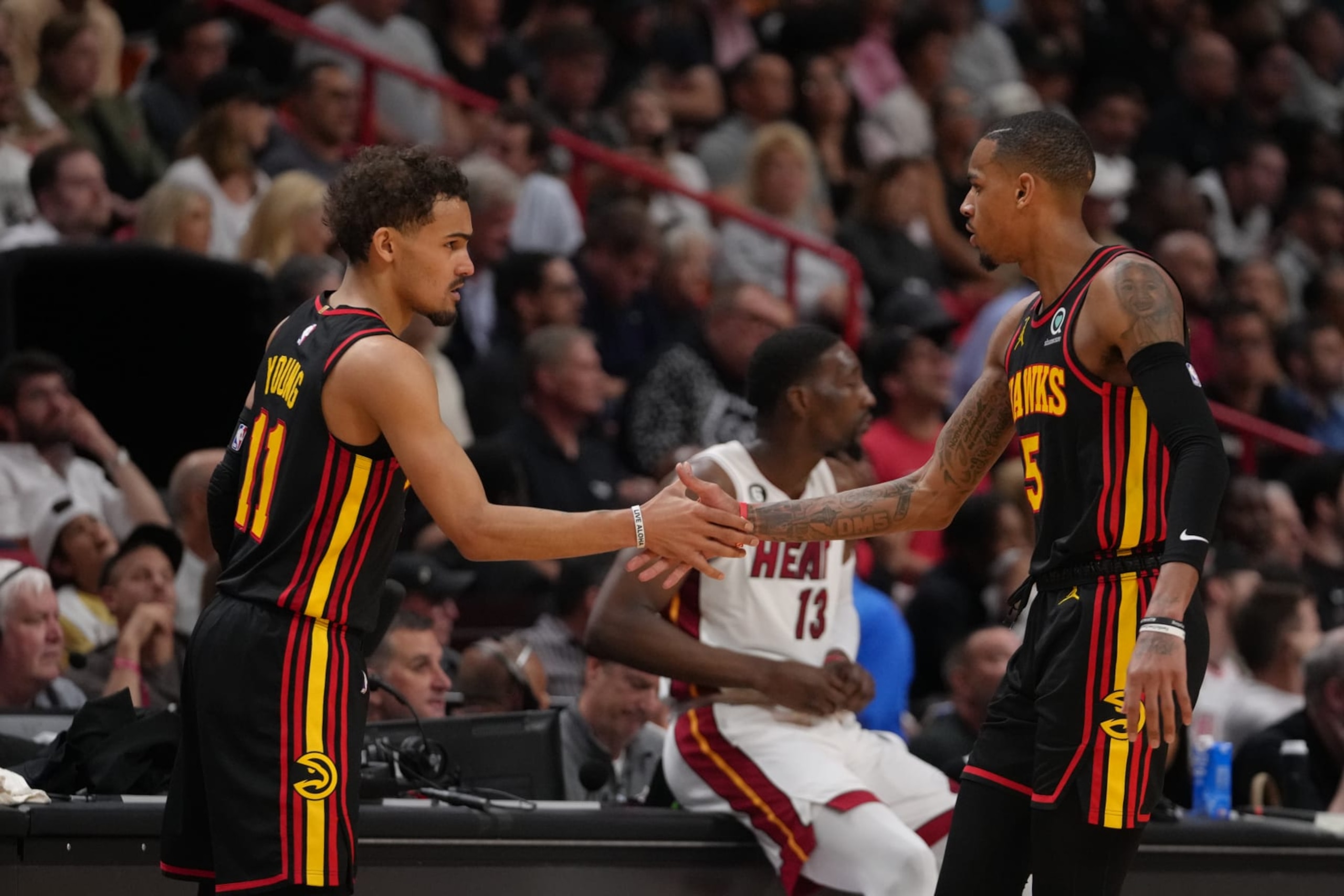 MIAMI, FL - APRIL 11: Trae Young #11 of the Atlanta Hawks high-fives teammate Dejounte Murray #5 during the 2023 Play-In Tournament against the Miami Heat on April 11, 2023 at Kaseya Center in Miami, Florida. NOTE TO USER: User expressly acknowledges and agrees that, by downloading and or using this Photograph, user is consenting to the terms and conditions of the Getty Images License Agreement. Mandatory Copyright Notice: Copyright 2023 NBAE (Photo by Eric Espada/NBAE via Getty Images)