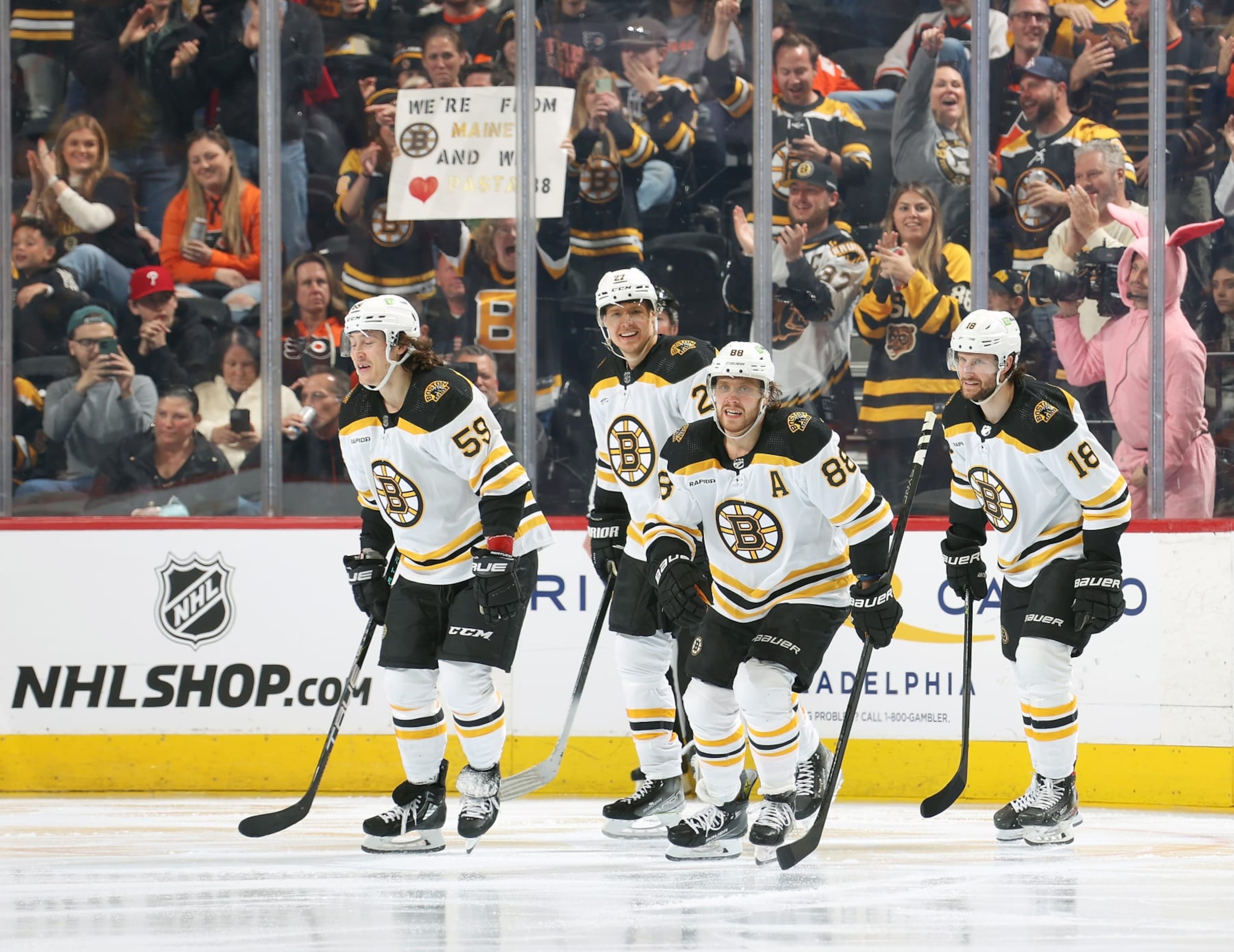 PHILADELPHIA, PENNSYLVANIA - APRIL 09:  David Pastrnak #88 of the Boston Bruins skates toward the bench following his third period goal against the Philadelphia Flyers with Tyler Bertuzzi #59, Hampus Lindholm #27 and Pavel Zacha #18 at the Wells Fargo Center on April 9, 2023 in Philadelphia, Pennsylvania.  The goal was the 60th regular season and the 300th of Pastrnak's NHL career.  (Photo by Len Redkoles/NHLI via Getty Images)