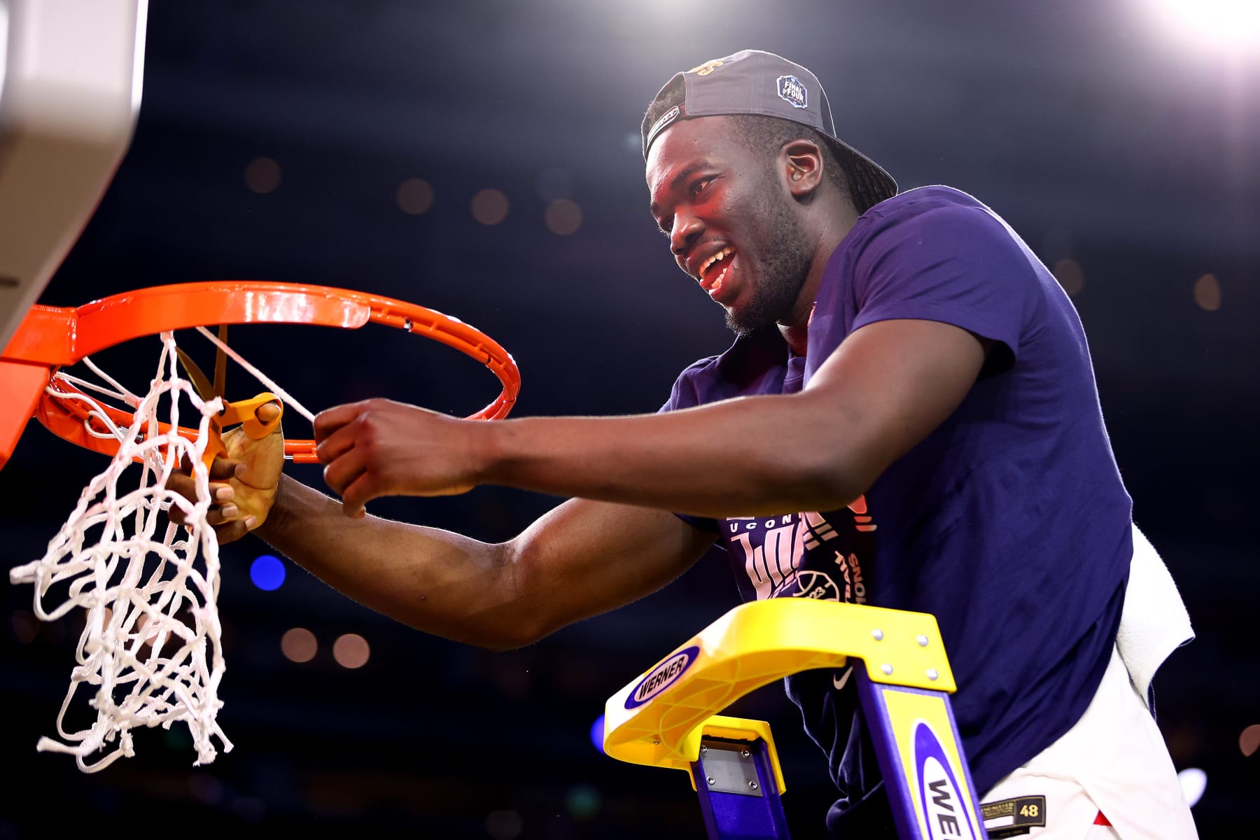 HOUSTON, TEXAS - APRIL 03: Adama Sanogo #21 of the Connecticut Huskies cuts the net after defeating the San Diego State Aztecs to win the NCAA Men's Basketball Tournament National Championship at NRG Stadium on April 03, 2023 in Houston, Texas. (Photo by Jamie Schwaberow/NCAA Photos via Getty Images)