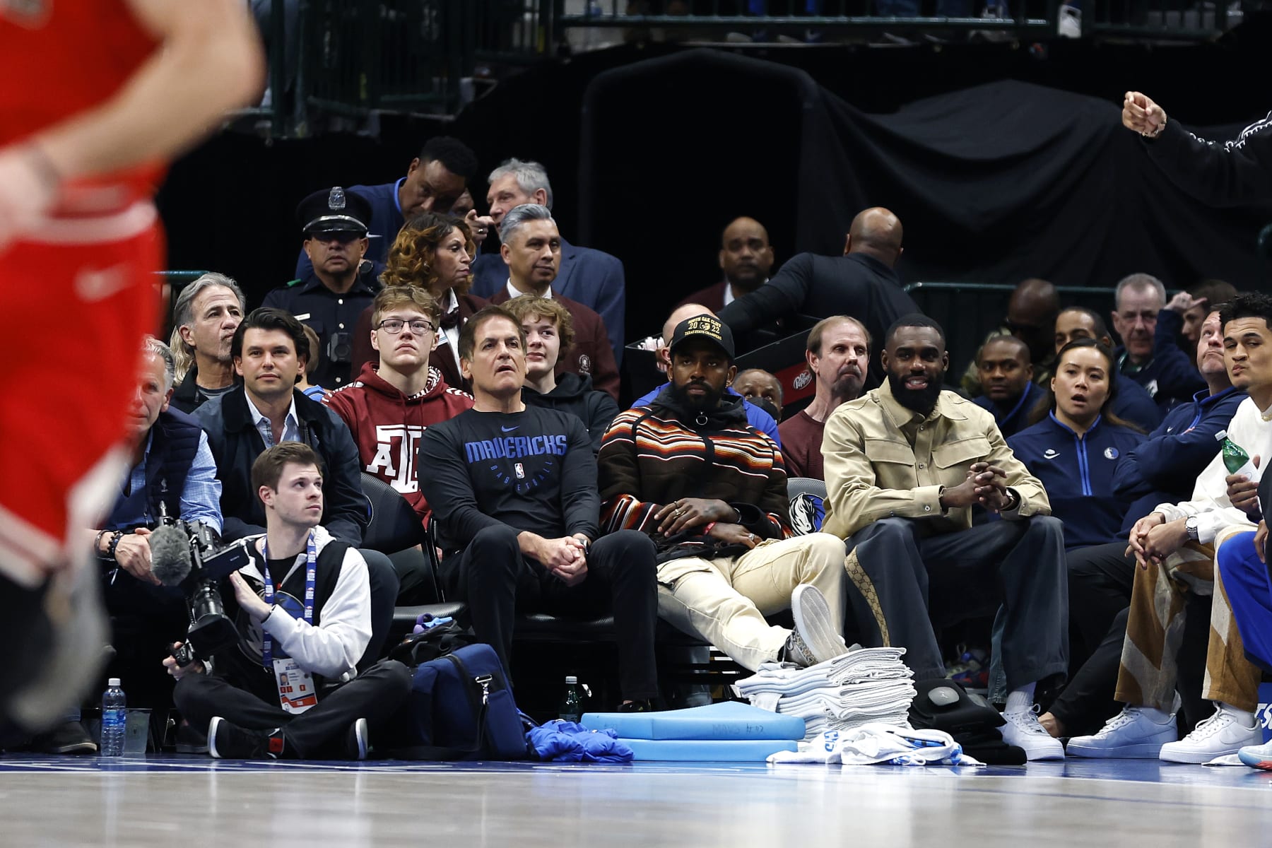 DALLAS, TEXAS - APRIL 07: (L to R) Dallas Mavericks owner Mark Cuban,  Kyrie Irving and Tim Hardaway Jr. sit court side during the game against the Chicago Bulls at American Airlines Center on April 07, 2023 in Dallas, Texas. NOTE TO USER: User expressly acknowledges and agrees that, by downloading and or using this photograph, User is consenting to the terms and conditions of the Getty Images License Agreement. (Photo by Tim Heitman/Getty Images)