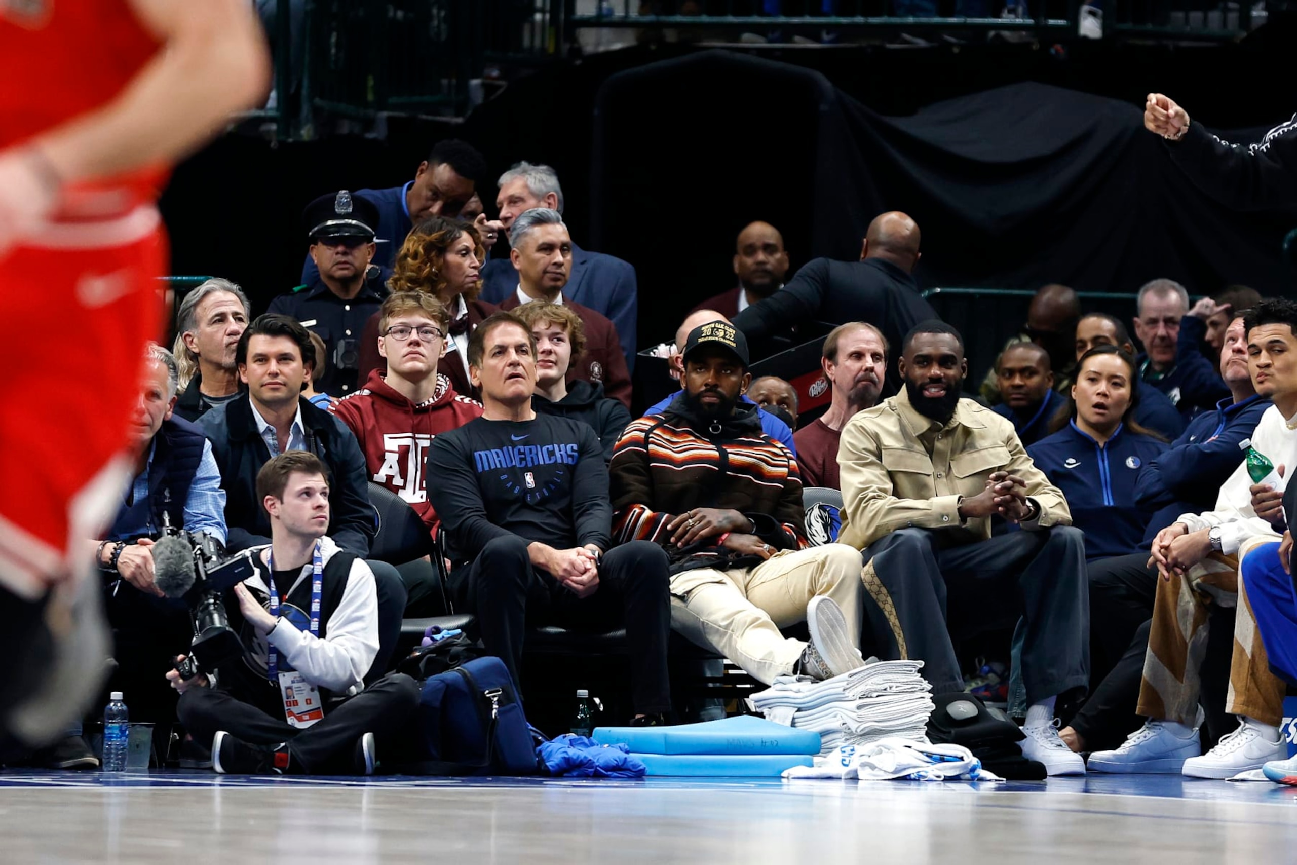 DALLAS, TEXAS - APRIL 07: (L to R) Dallas Mavericks owner Mark Cuban,  Kyrie Irving and Tim Hardaway Jr. sit court side during the game against the Chicago Bulls at American Airlines Center on April 07, 2023 in Dallas, Texas. NOTE TO USER: User expressly acknowledges and agrees that, by downloading and or using this photograph, User is consenting to the terms and conditions of the Getty Images License Agreement. (Photo by Tim Heitman/Getty Images)