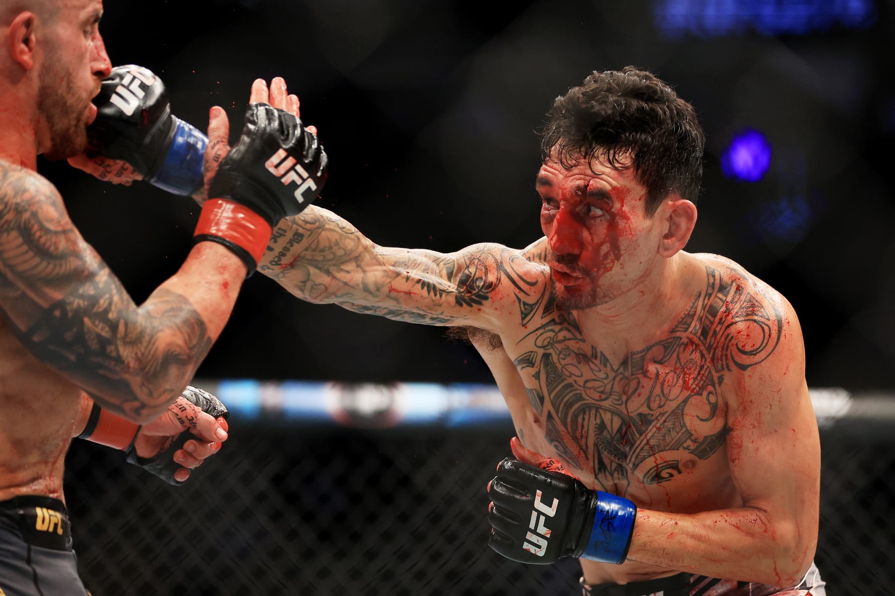 LAS VEGAS, NEVADA - JULY 02: Max Holloway (R) punches Alexander Volkanovski of Australia in their featherweight title bout during UFC 276 at T-Mobile Arena on July 02, 2022 in Las Vegas, Nevada. (Photo by Carmen Mandato/Getty Images)