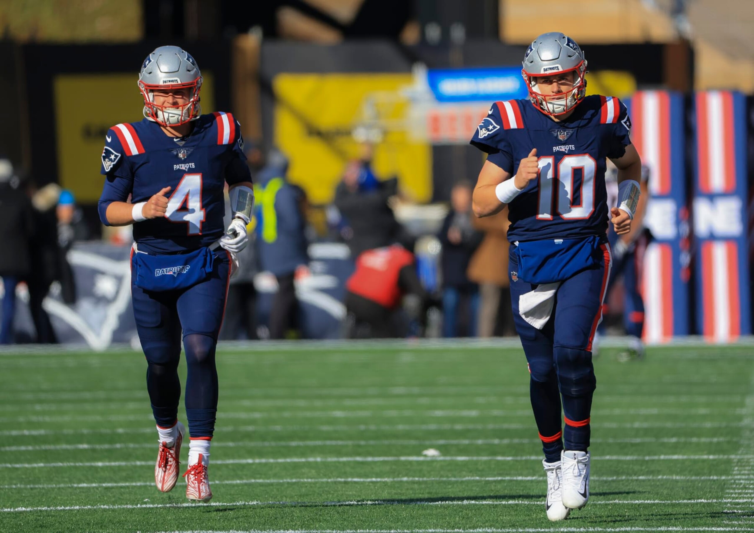 Foxborough, MA - November 20: New England QBs Bailey Zappe, left, and Mac Jones jog out onto the field before the game. The Patriots beat the New York Jets, 10-3. (Photo by Matthew J. Lee/The Boston Globe via Getty Images)
