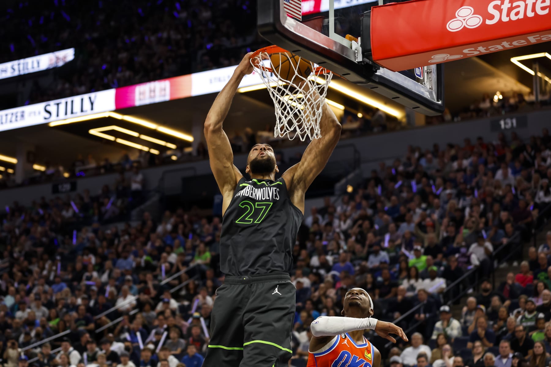 MINNEAPOLIS, MN - APRIL 14: Rudy Gobert #27 of the Minnesota Timberwolves dunks the ball on an alley-oop while Shai Gilgeous-Alexander #2 of the Oklahoma City Thunder looks on in the second quarter of the NBA Play-In game at Target Center on April 14, 2023 in Minneapolis, Minnesota. NOTE TO USER: User expressly acknowledges and agrees that, by downloading and or using this Photograph, user is consenting to the terms and conditions of the Getty Images License Agreement. (Photo by David Berding/Getty Images)