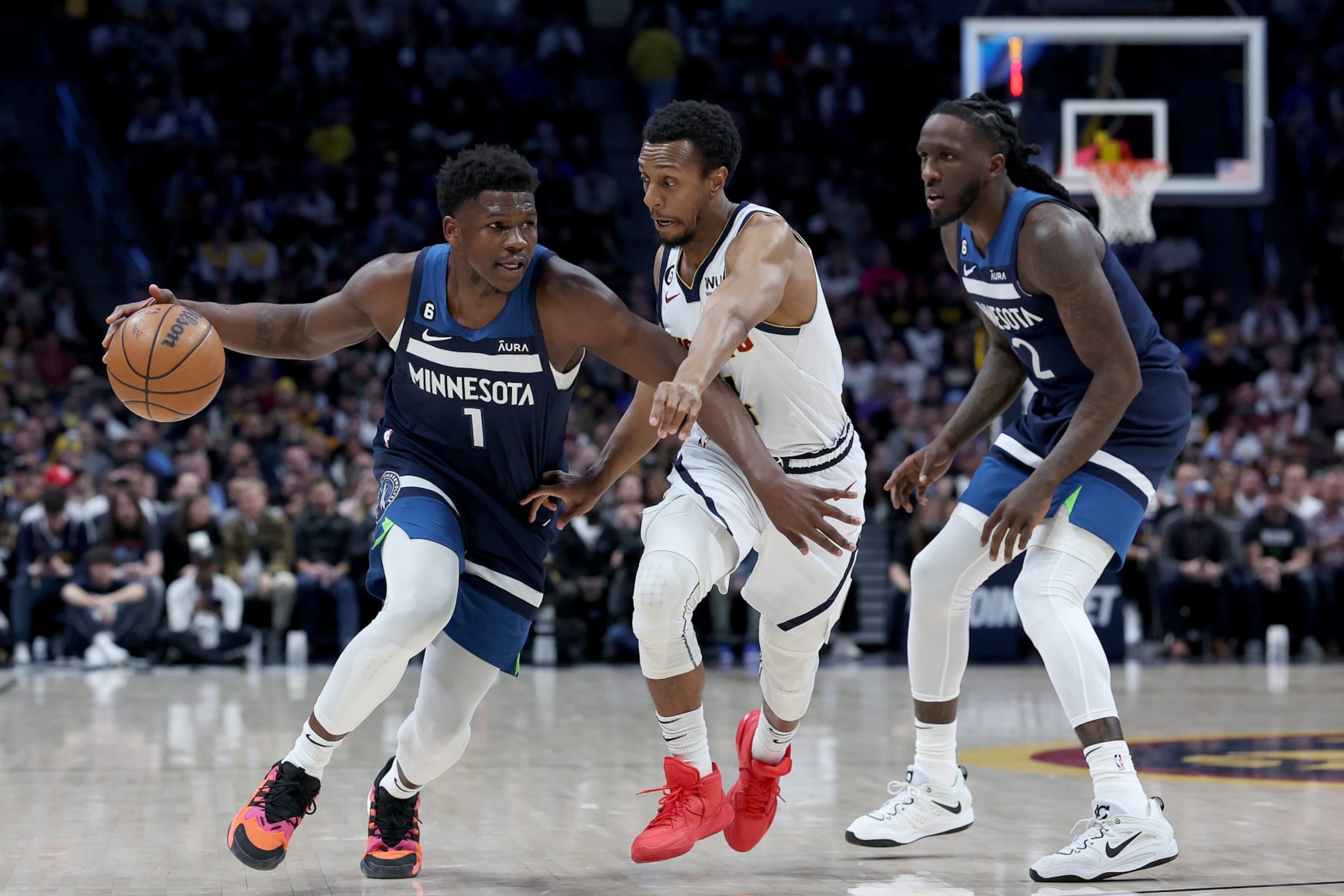 DENVER, COLORADO - FEBRUARY 07:  Anthony Edwards #1 of the Minnesota Timberwolves drives against Ish Smith #14 of the Denver Nuggets in the first quarter at Ball Arena on February 7, 2023 in Denver, Colorado. NOTE TO USER: User expressly acknowledges and agrees that, by downloading and/or using this photograph, User is consenting to the terms and conditions of the Getty Images License Agreement. (Photo by Matthew Stockman/Getty Images)